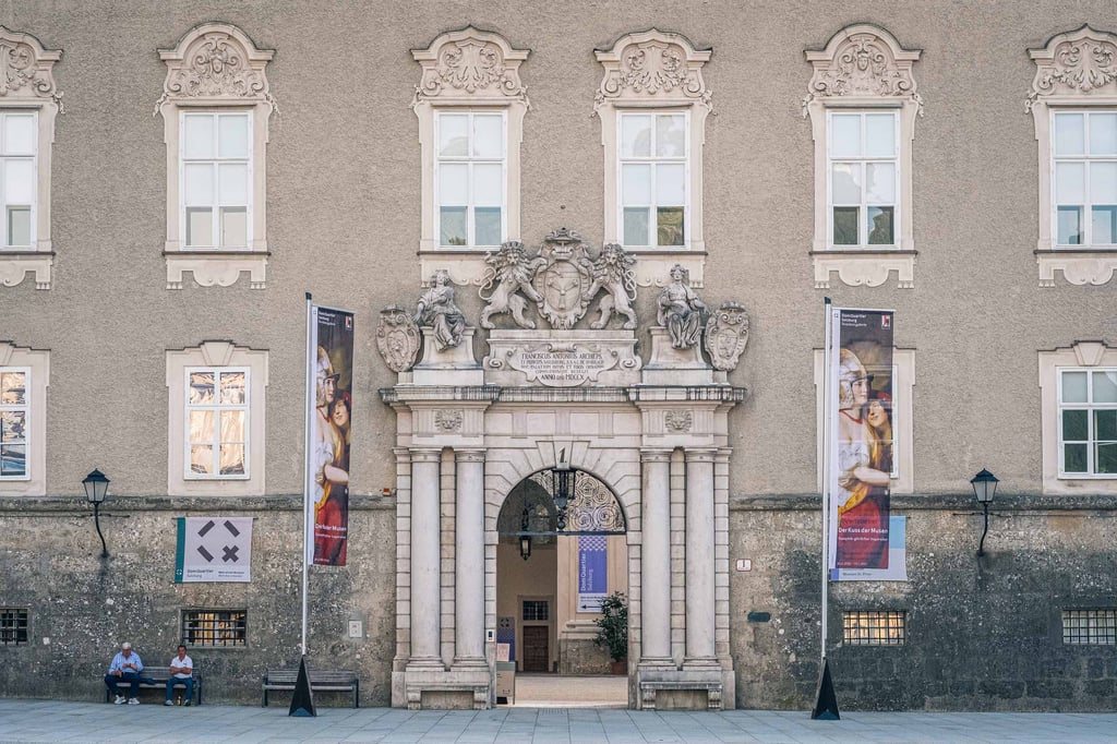 Baroque portal entrance of DomQuartier museum with heraldic coat of arms above the door in Salzburg