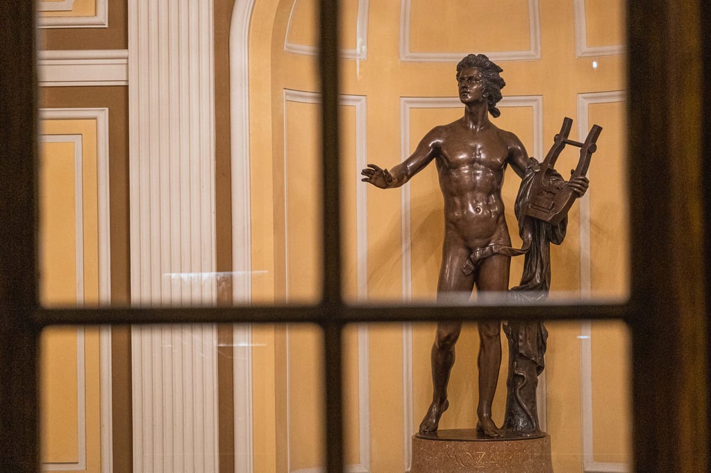 Bronze Apollo with lyre statue seen through a window at the Stiftung Mozarteum / Mozarteum Foundation building in Salzburg