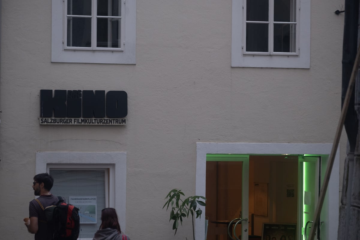 Das Kino Salzburger Filmkulturzentrum entrance with signage and lit green doorway in Salzburg