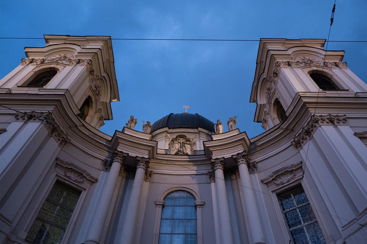 The facade of the Dreifaltigkeitskirche at dusk, built by Johann Bernhard Fischer von Erlach