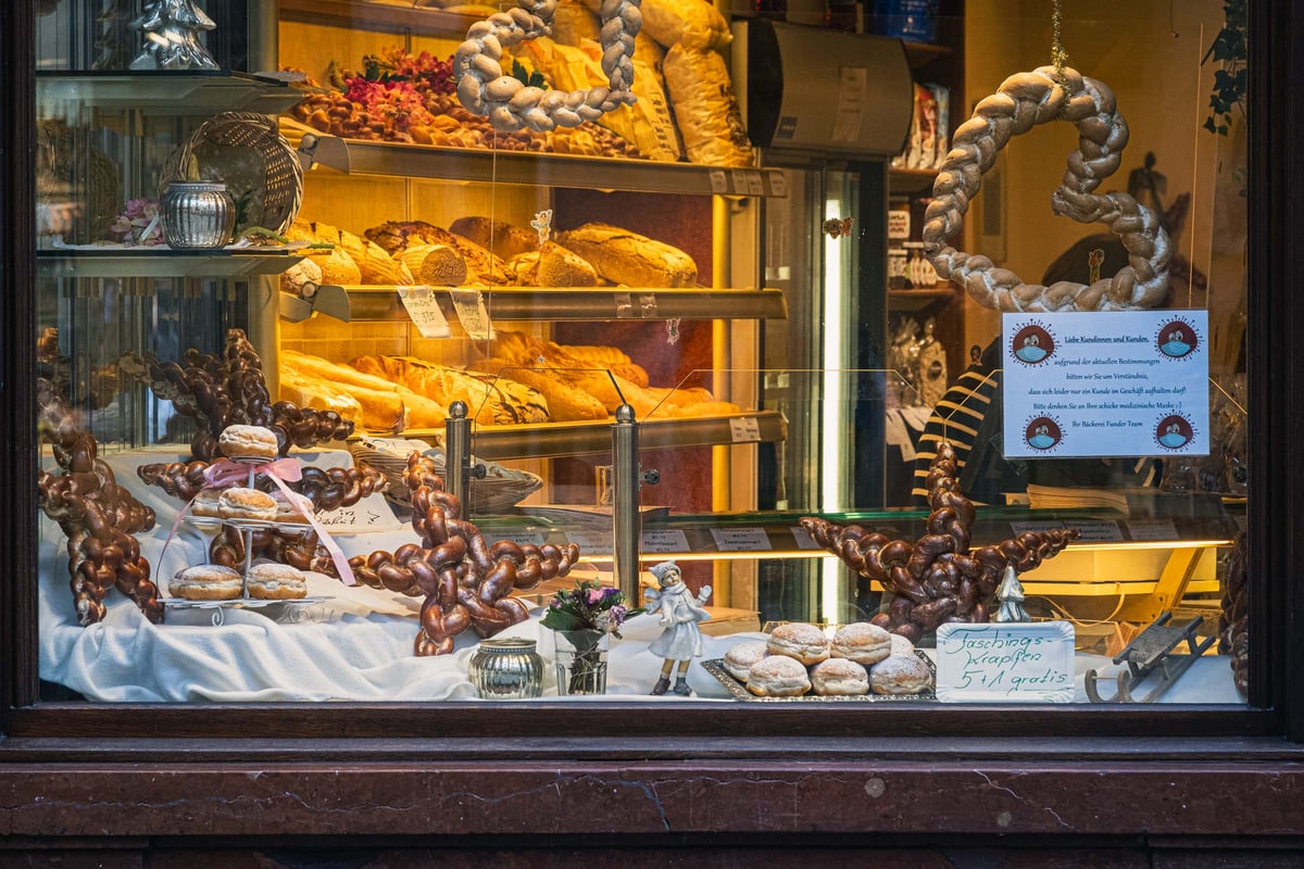 Bakery window display with braided Salzburger pastries Krapfen and pretzels in Salzburg old town.