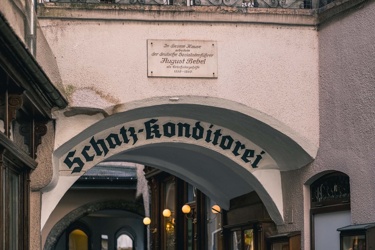 Arched passage entrance with Schatz Konditorei signage in Salzburg old town