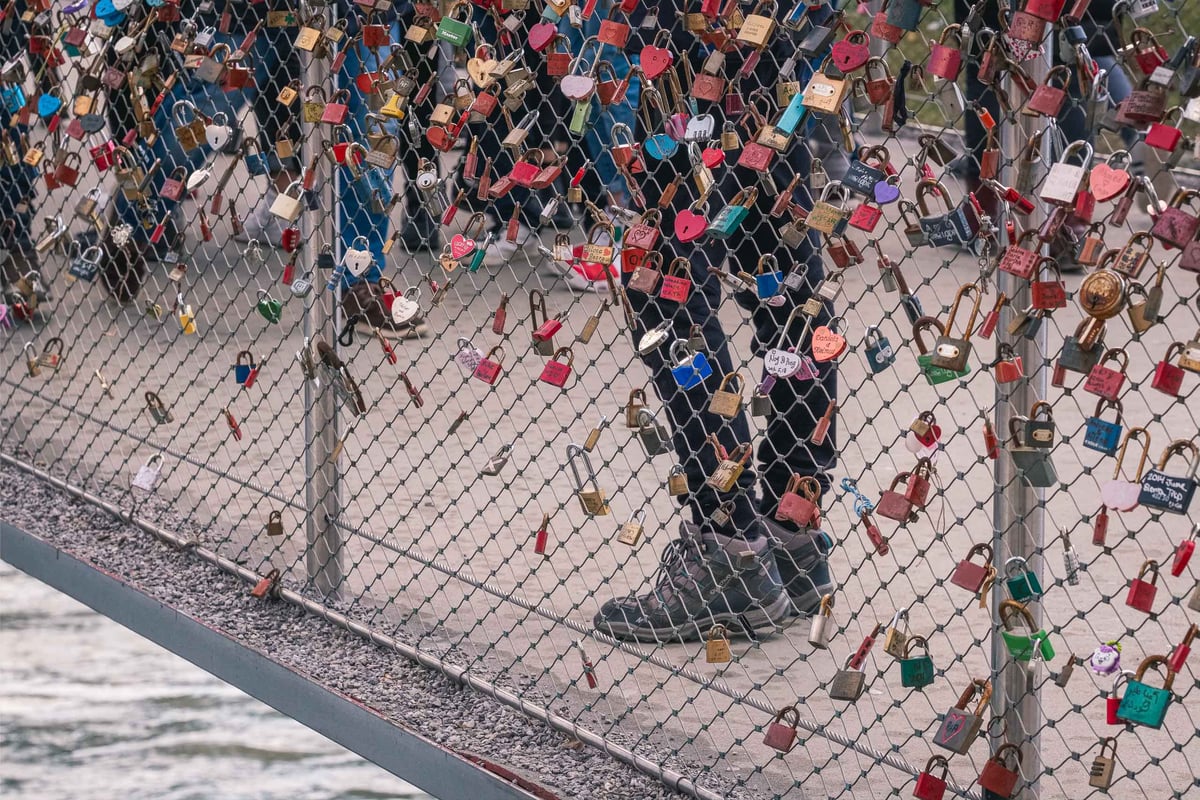 Dense love locks attached to the mesh railing of Makartsteg pedestrian bridge in Salzburg.