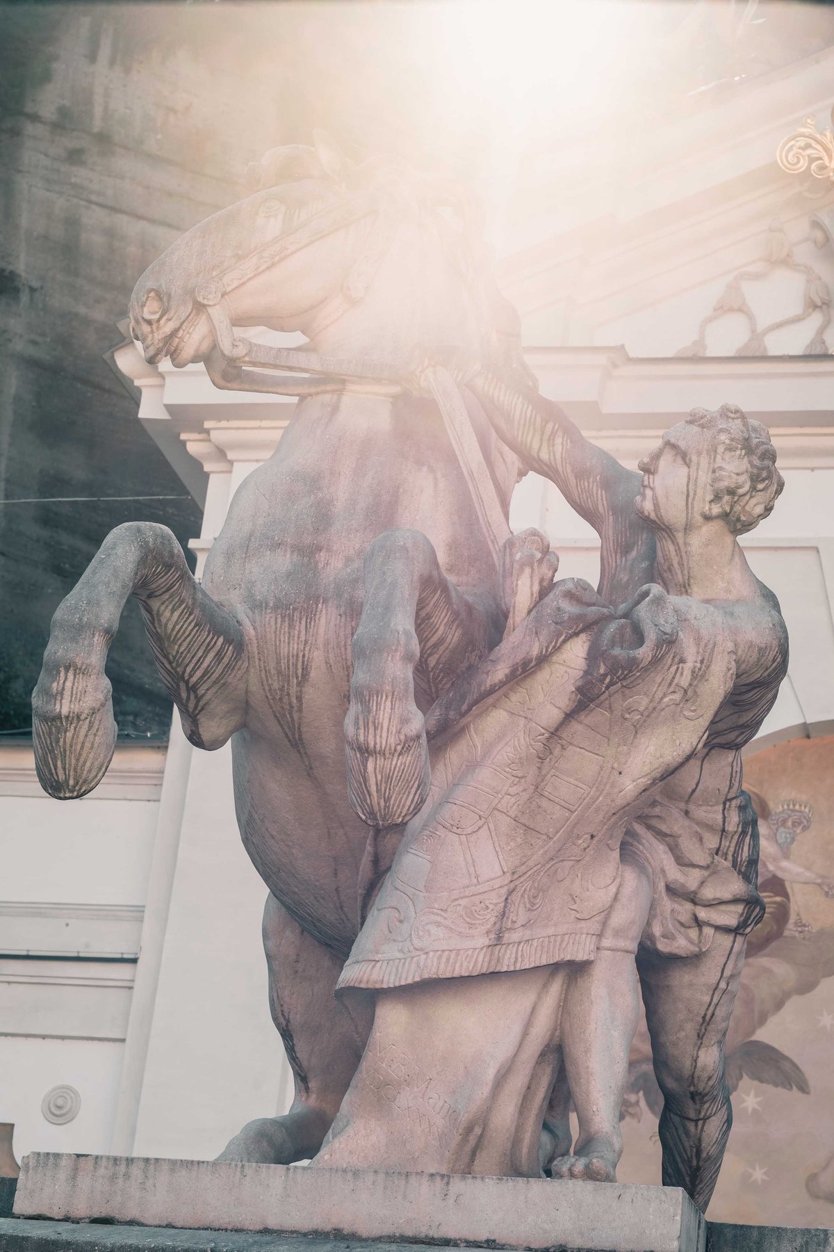Pferdeschwemme horse and tamer sculpture backlit by sunlight in Salzburg old town
