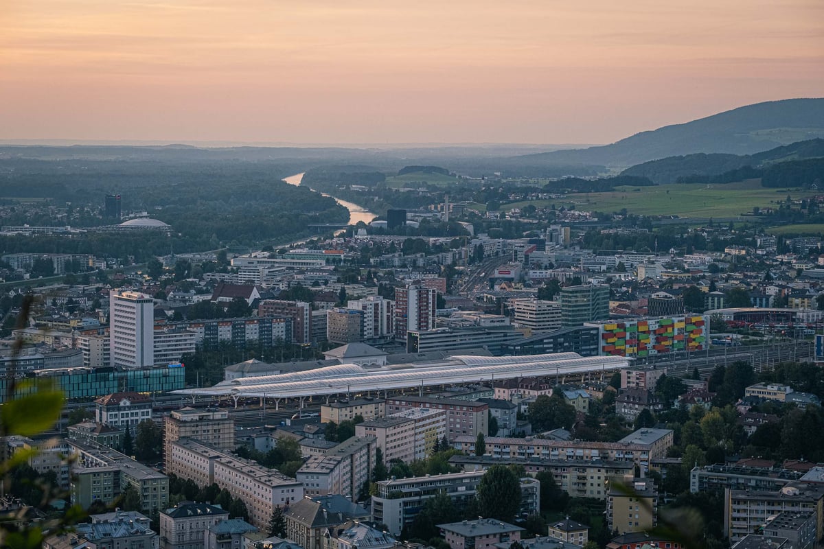 Salzburg Hauptbahnhof and northern city with Salzach bend visible at dusk from Kapuzinerberg