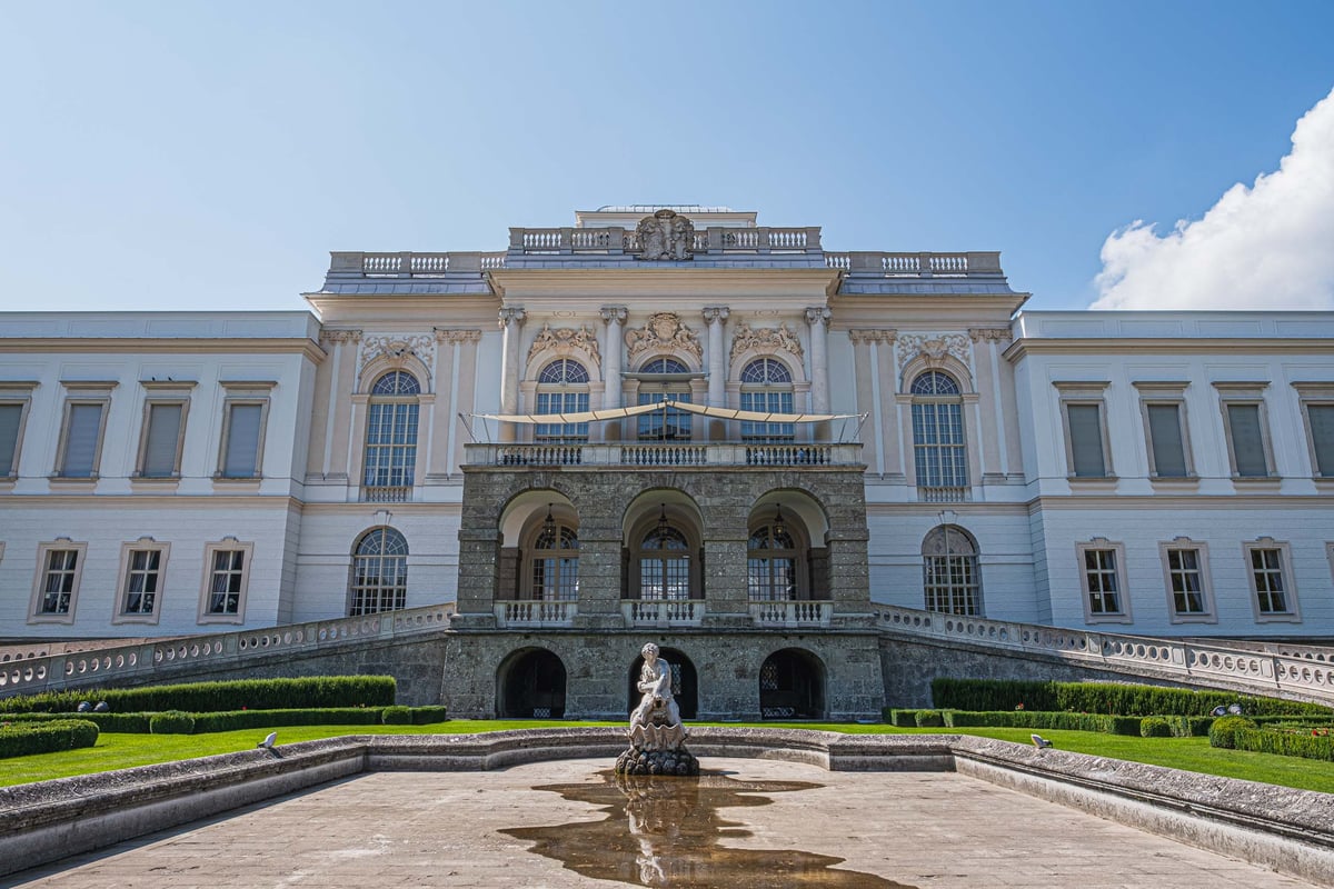 Baroque facade of Schloss Klessheim casino with garden and fountain in Salzburg.