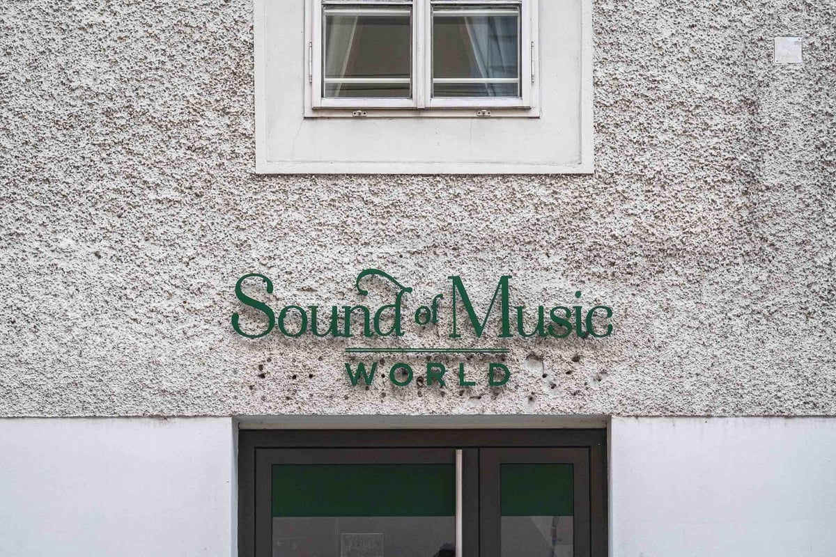 Sound of Music World green lettering signage above entrance door on building facade in Salzburg