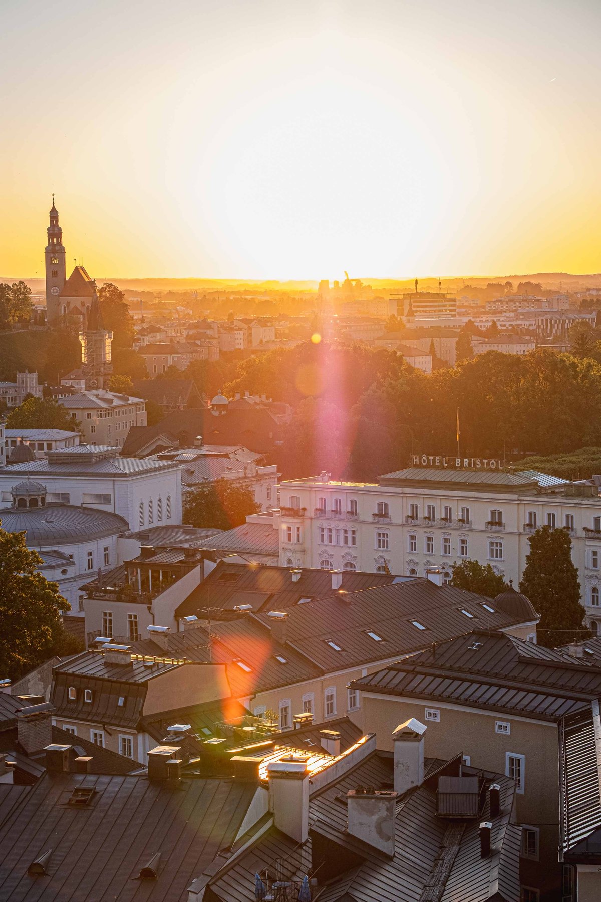 Hotel Bristol rooftop view at sunset from Steinterrasse with Mulln church tower in distance.