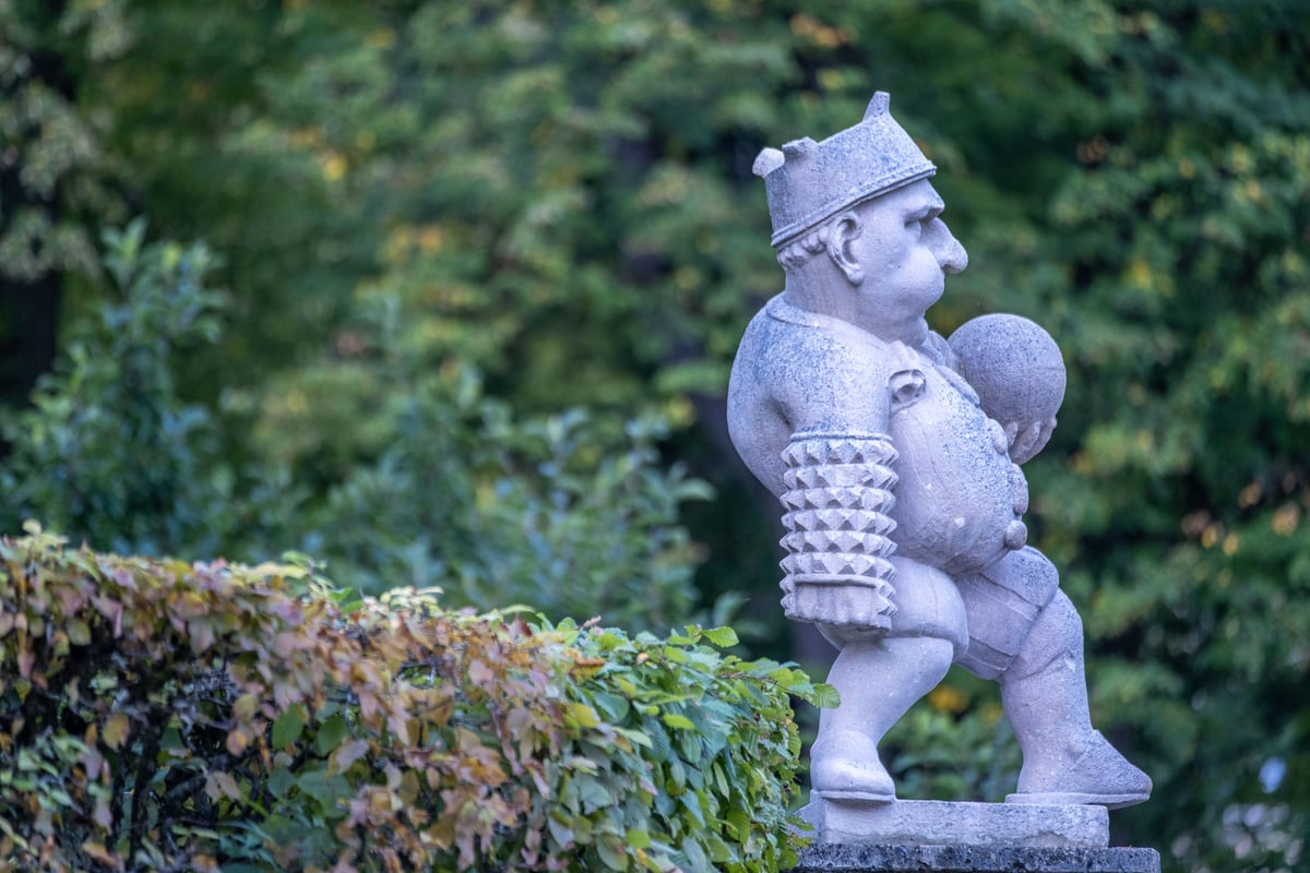 Carved marble dwarf sculpture with armour basket in the Zwerglgarten of Mirabell Gardens in Salzburg