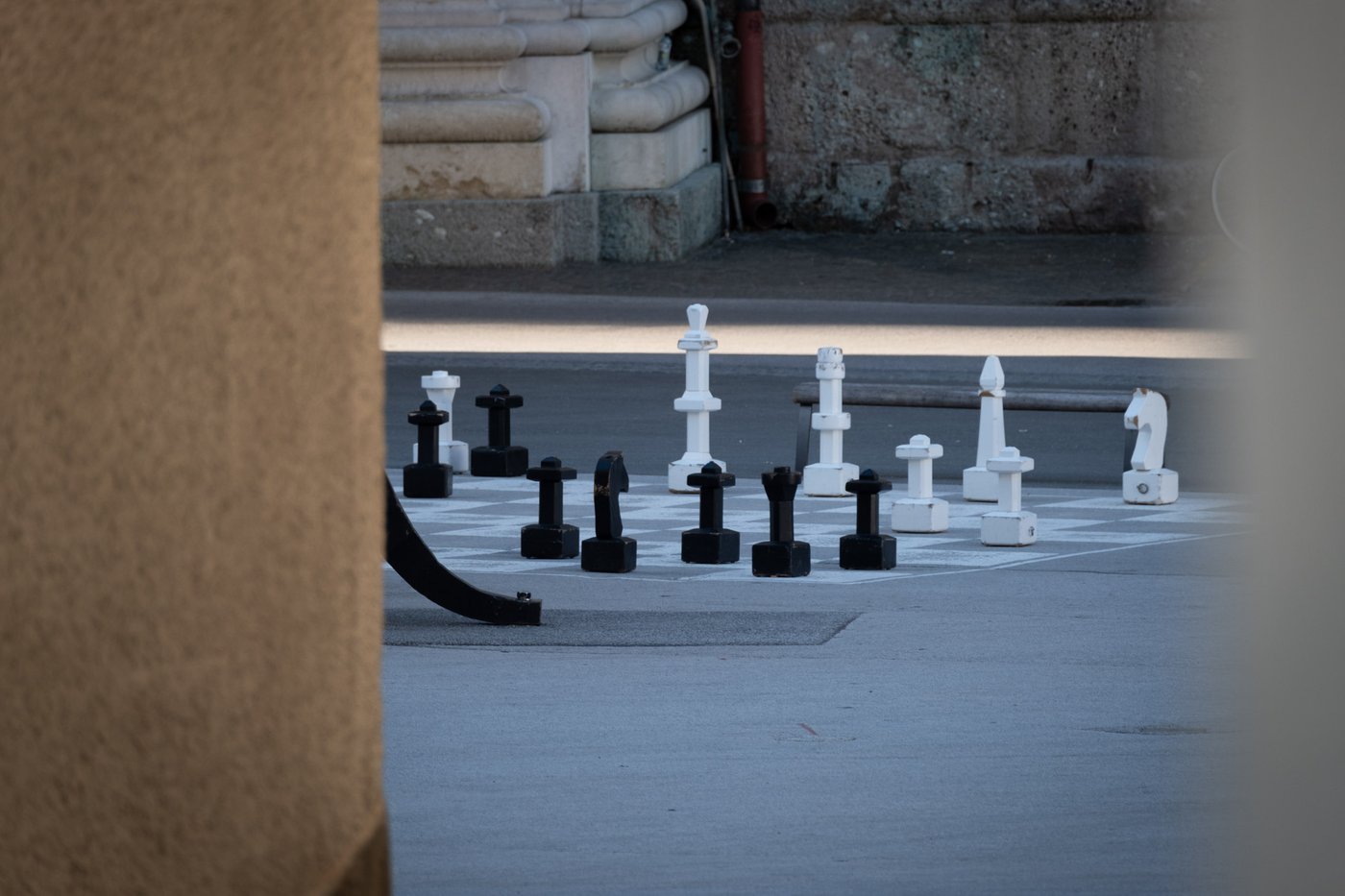 Oversized black and white chess pieces mid-game on the giant board at Kapitelplatz in Salzburg.