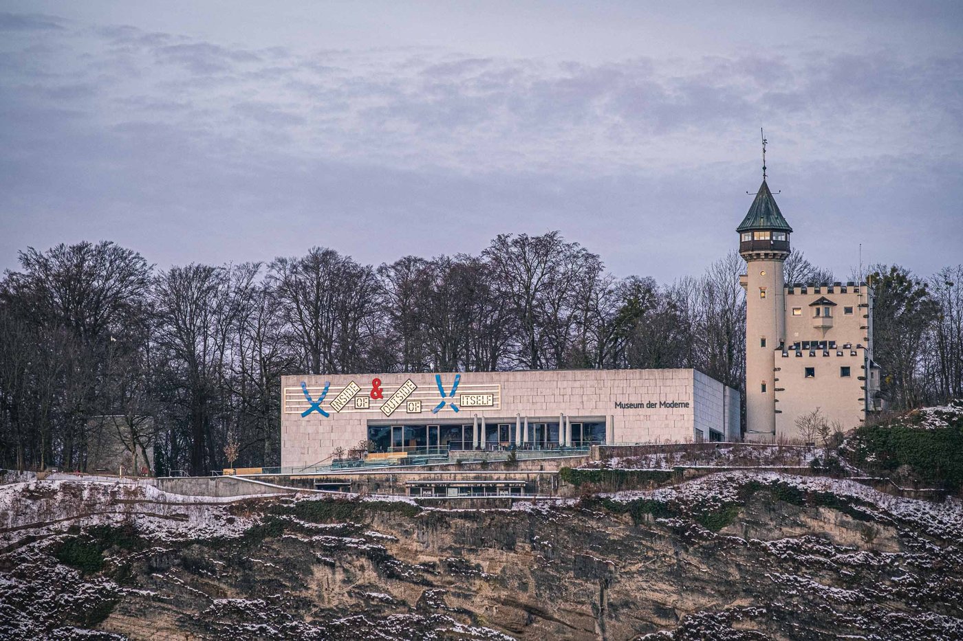 Museum der Moderne on Moenchsberg with its stone tower seen across the cliff face in winter in Salzburg.