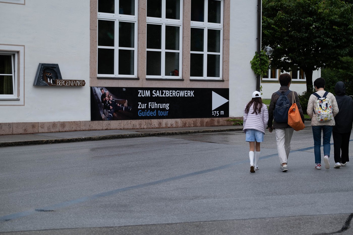 Visitors walk toward the guided-tour entrance sign of the Salzbergwerk in Berchtesgaden