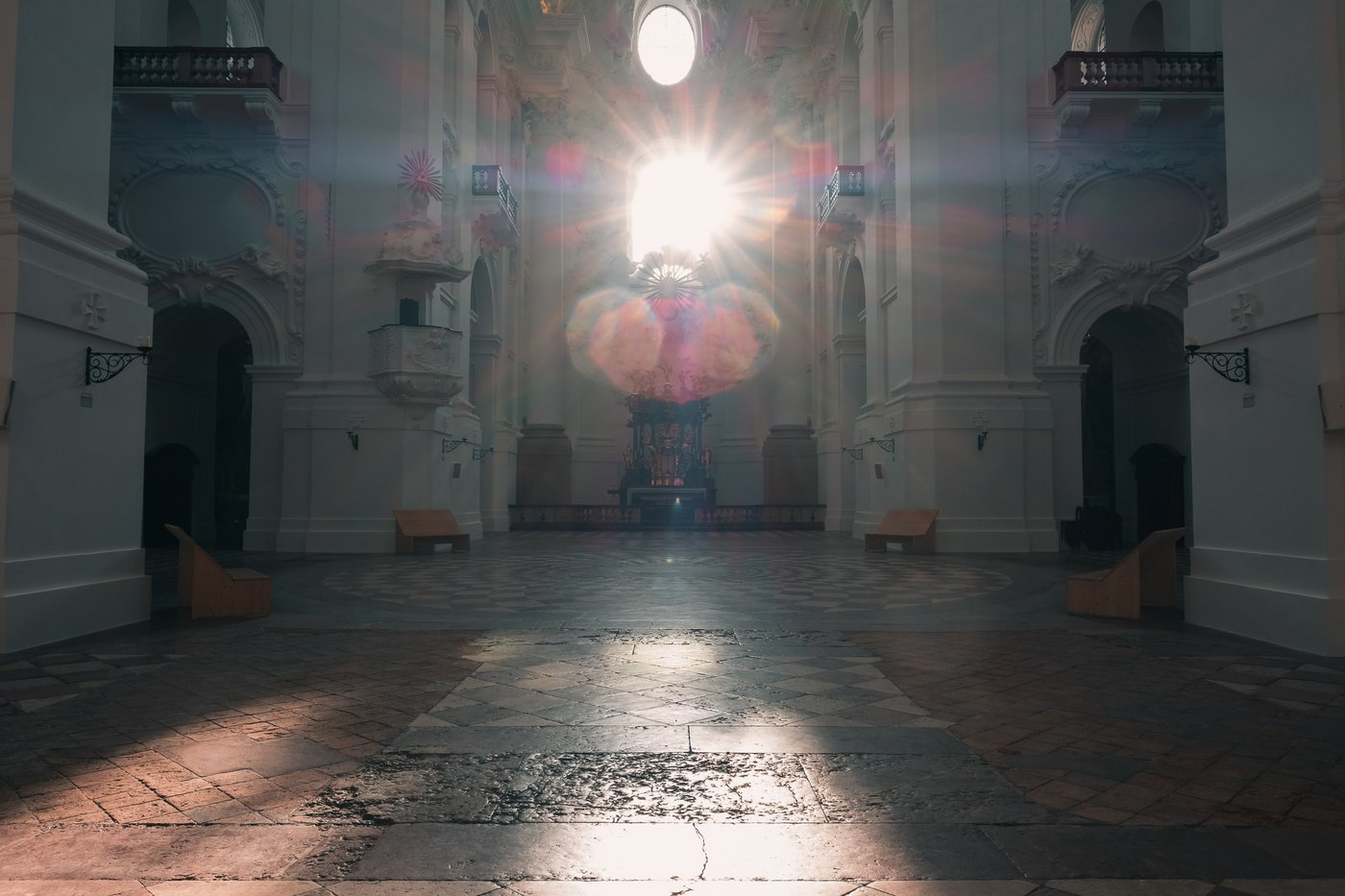 Sunburst streams through the oculus of the Kollegienkirche baroque nave in Salzburg old town
