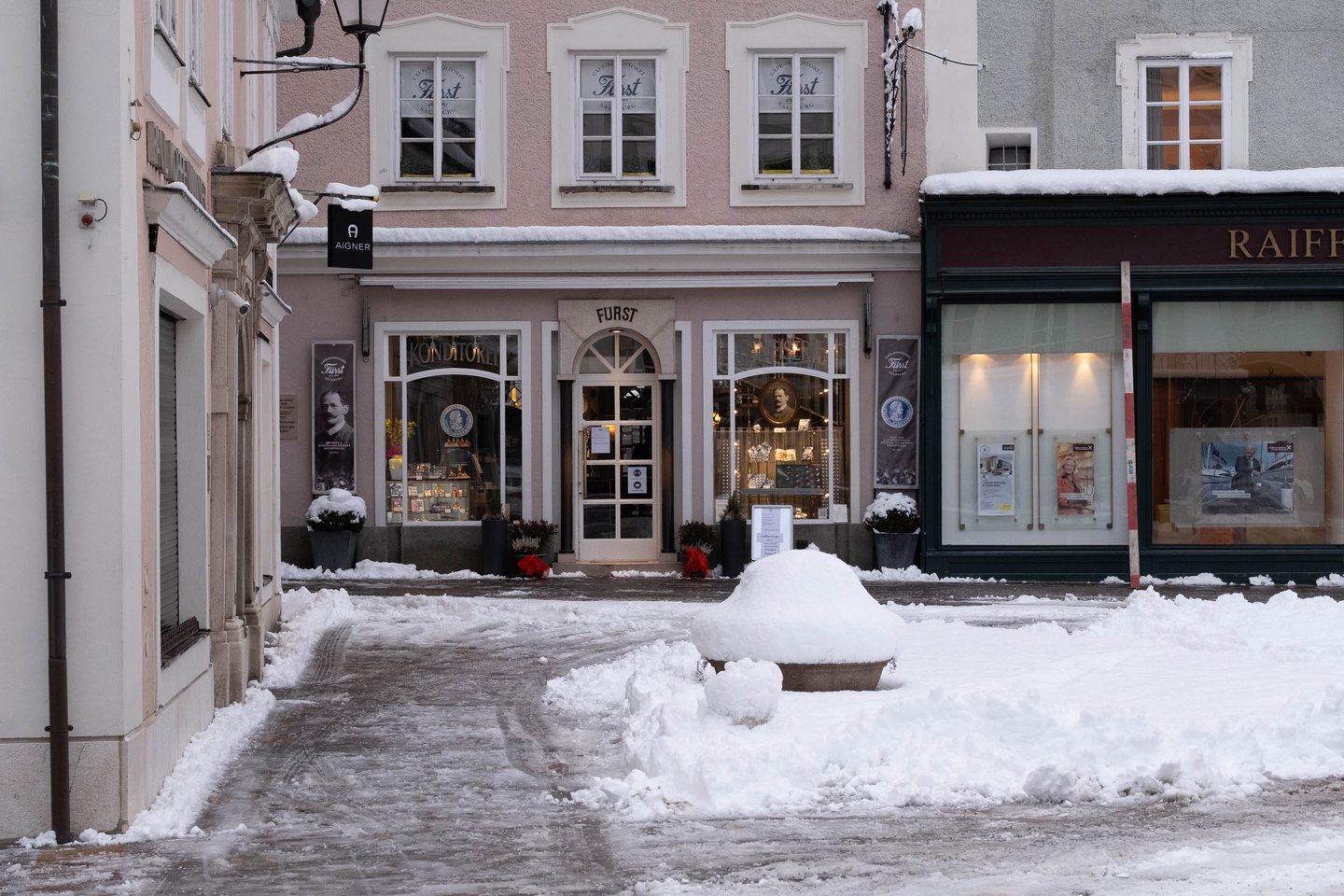Cafe Fuerst confectionery shop facade at Alter Markt after heavy snowfall in Salzburg old town.