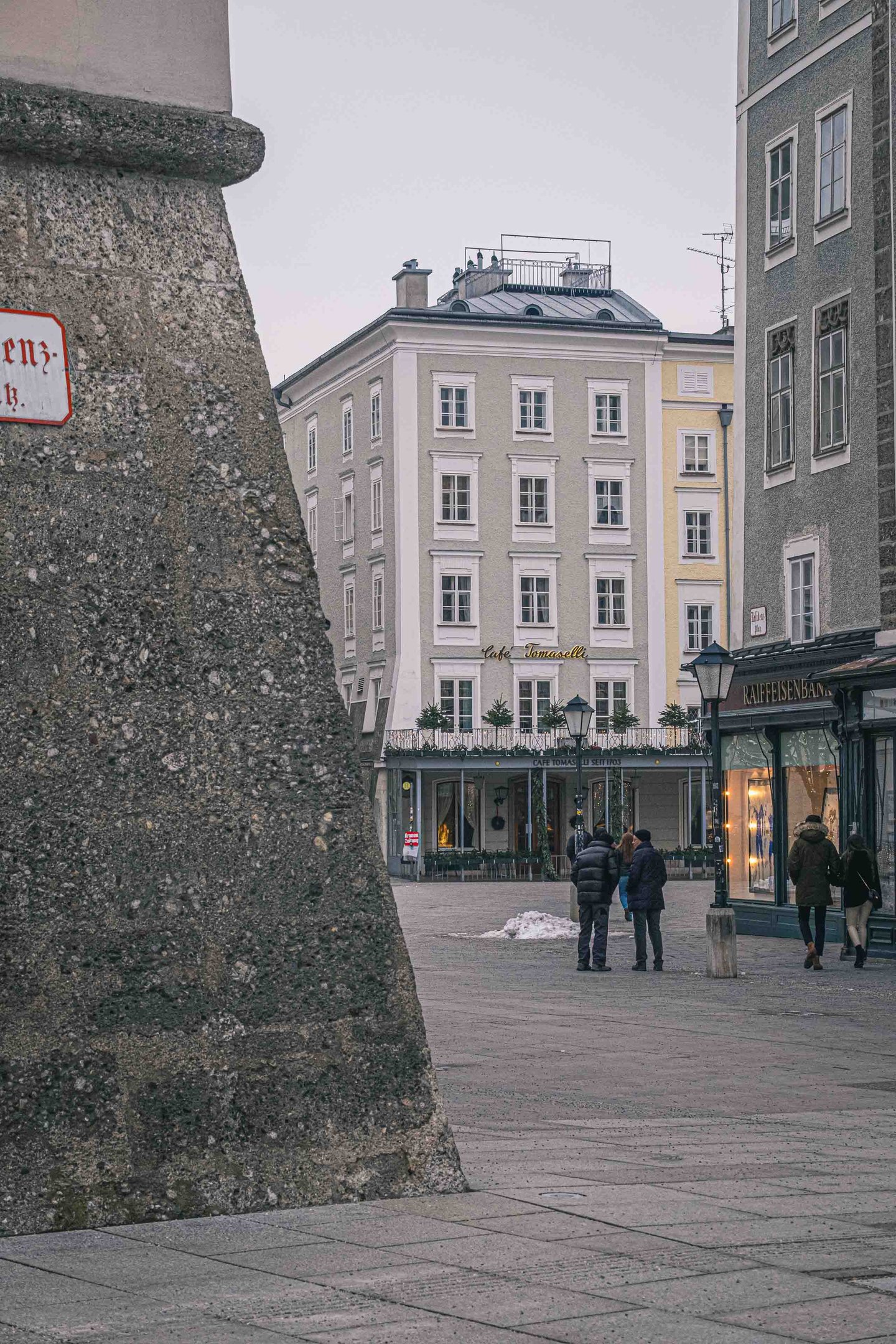 Alter Markt square with Cafe Tomaselli facade and people gathered in Salzburg old town.