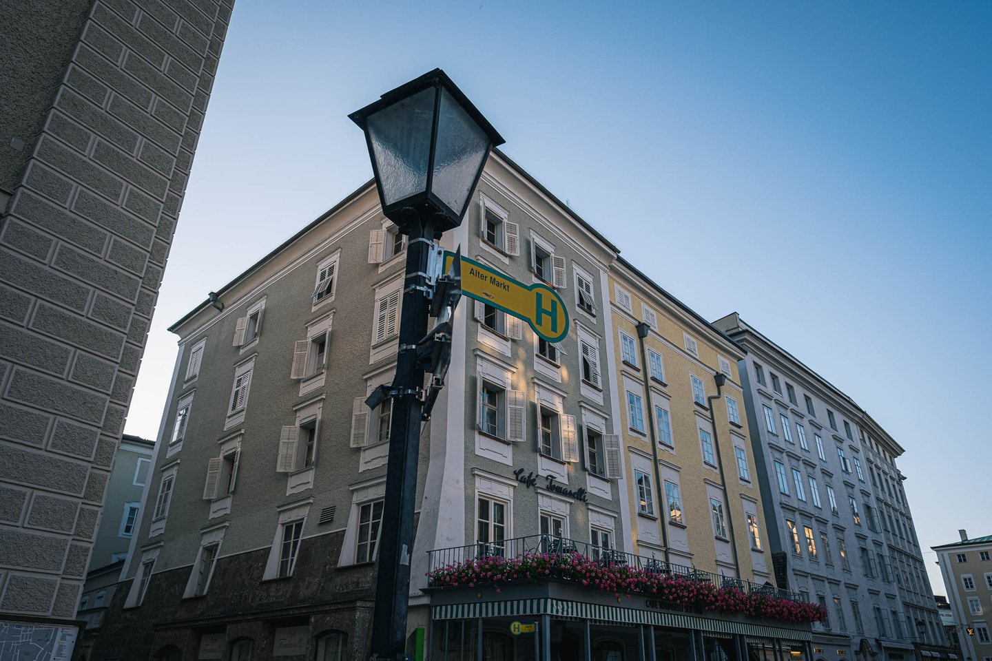 Street lamp with Alter Markt signpost and baroque facades in Salzburg old town.