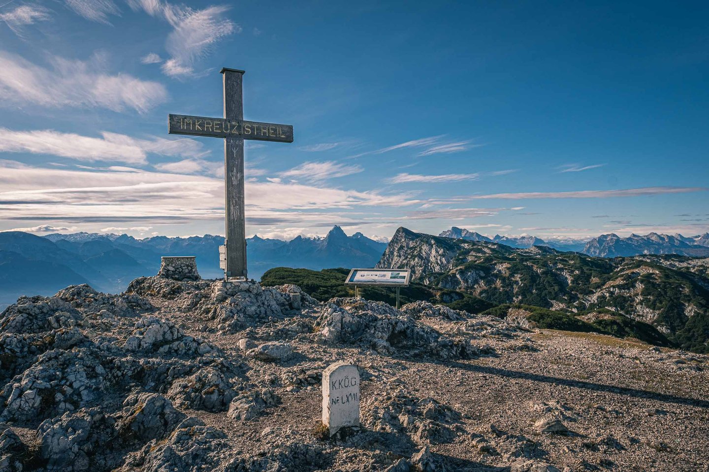 Summit cross with Im Kreuz ist Heil inscription at Berchtesgadener Hochthron with Alps behind