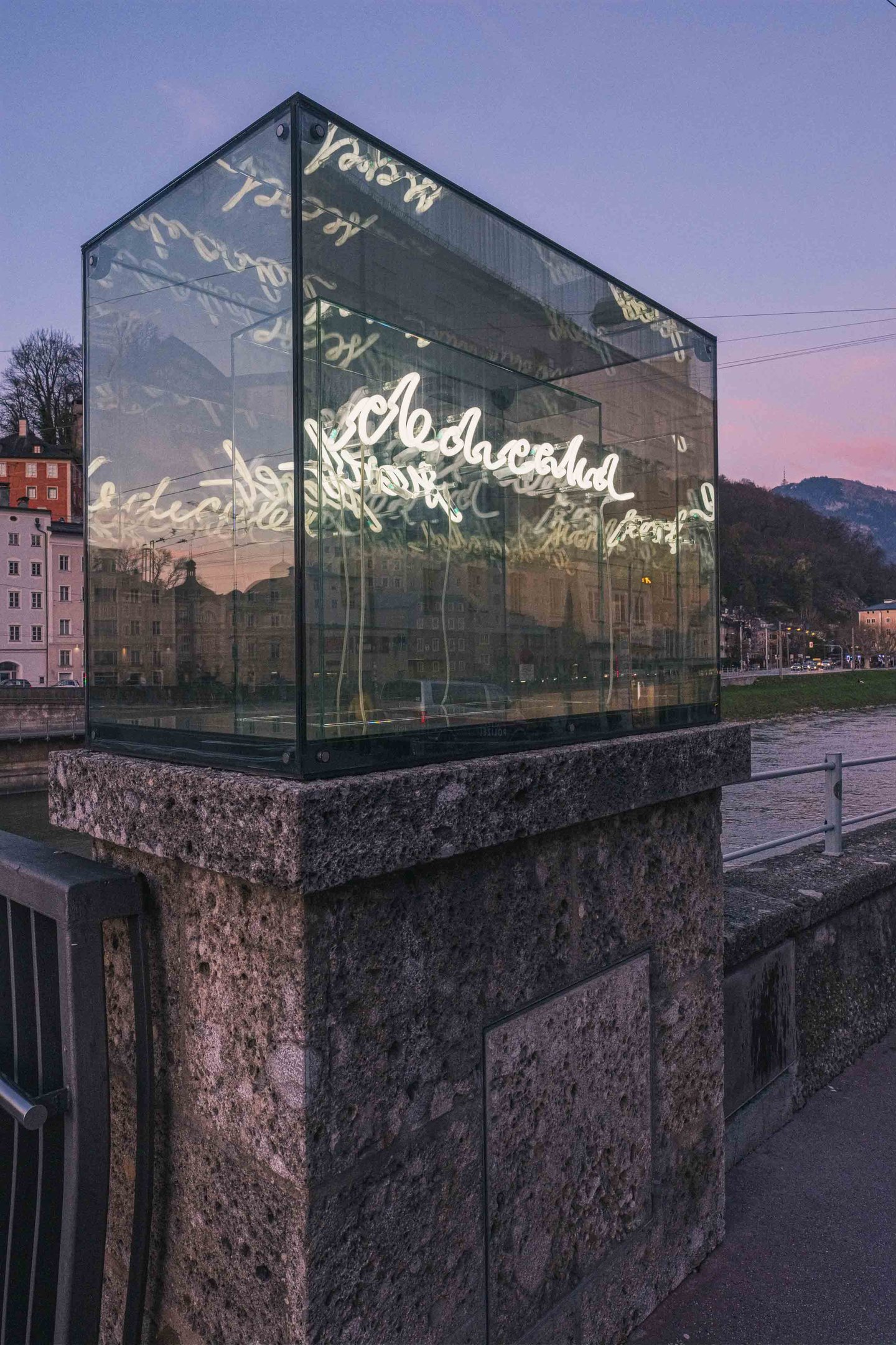 Beyond Recall illuminated vitrine in context along the Salzach in Salzburg, part of the Walk of Modern Art