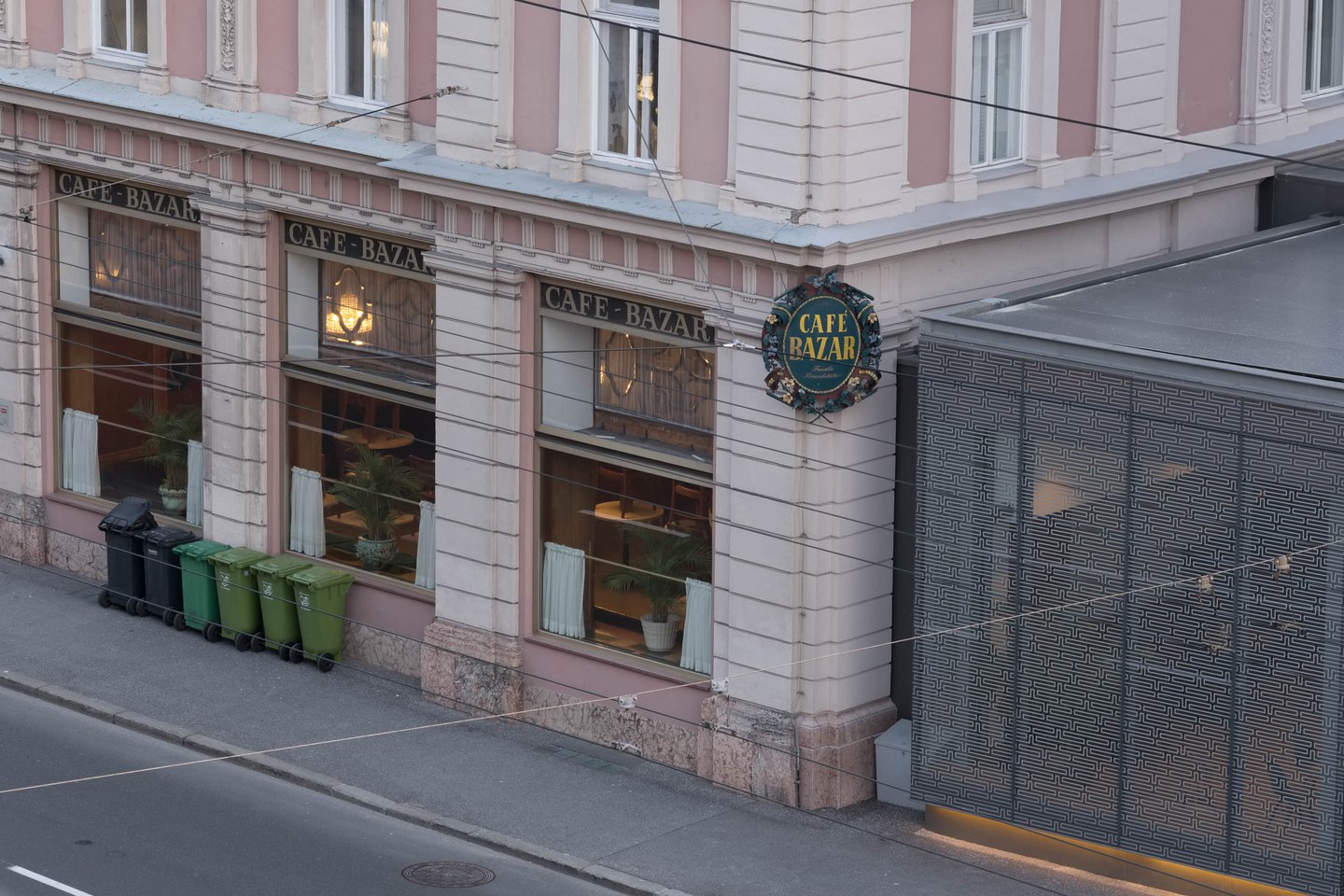 Cafe Bazar pink corner facade with its painted sign and window awnings in Salzburg Neustadt.