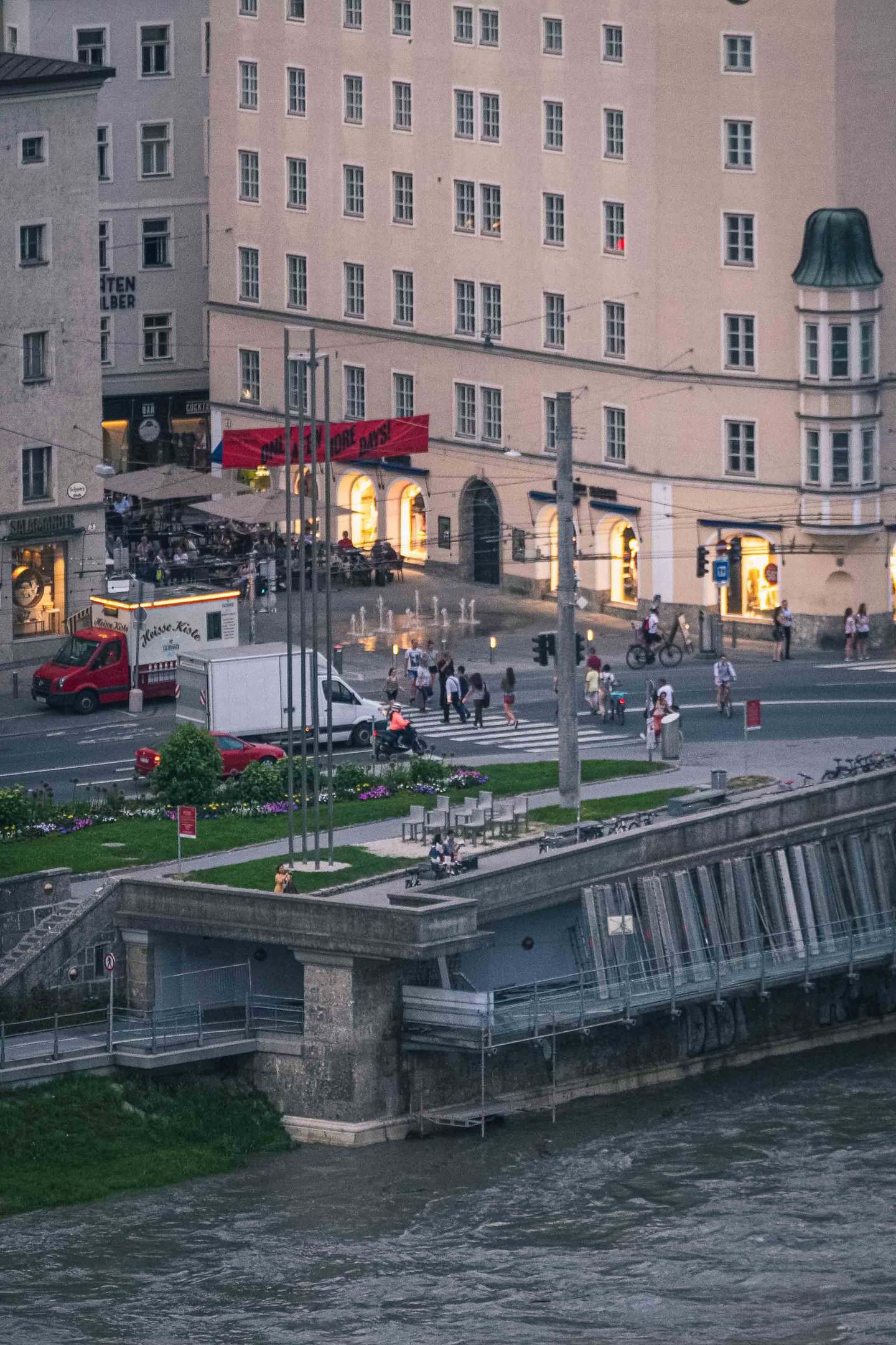 Wide view of the Cafe Bazar building on Schwarzstrasse seen from an elevated Altstadt vantage across the Salzach