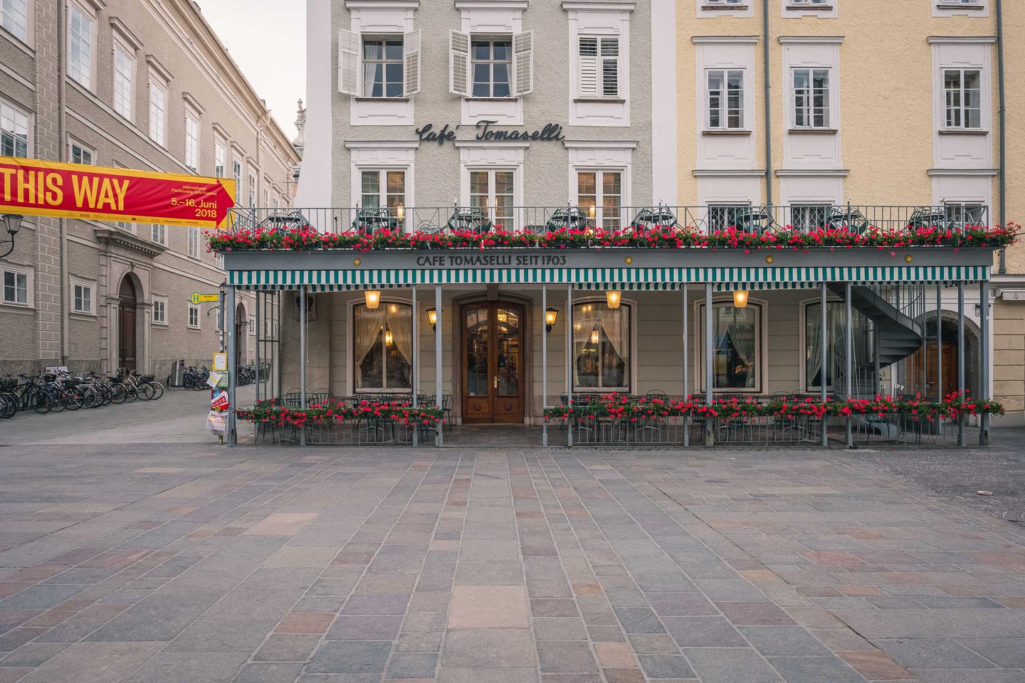 Cafe Tomaselli facade with red awning on Alter Markt square in Salzburg old town