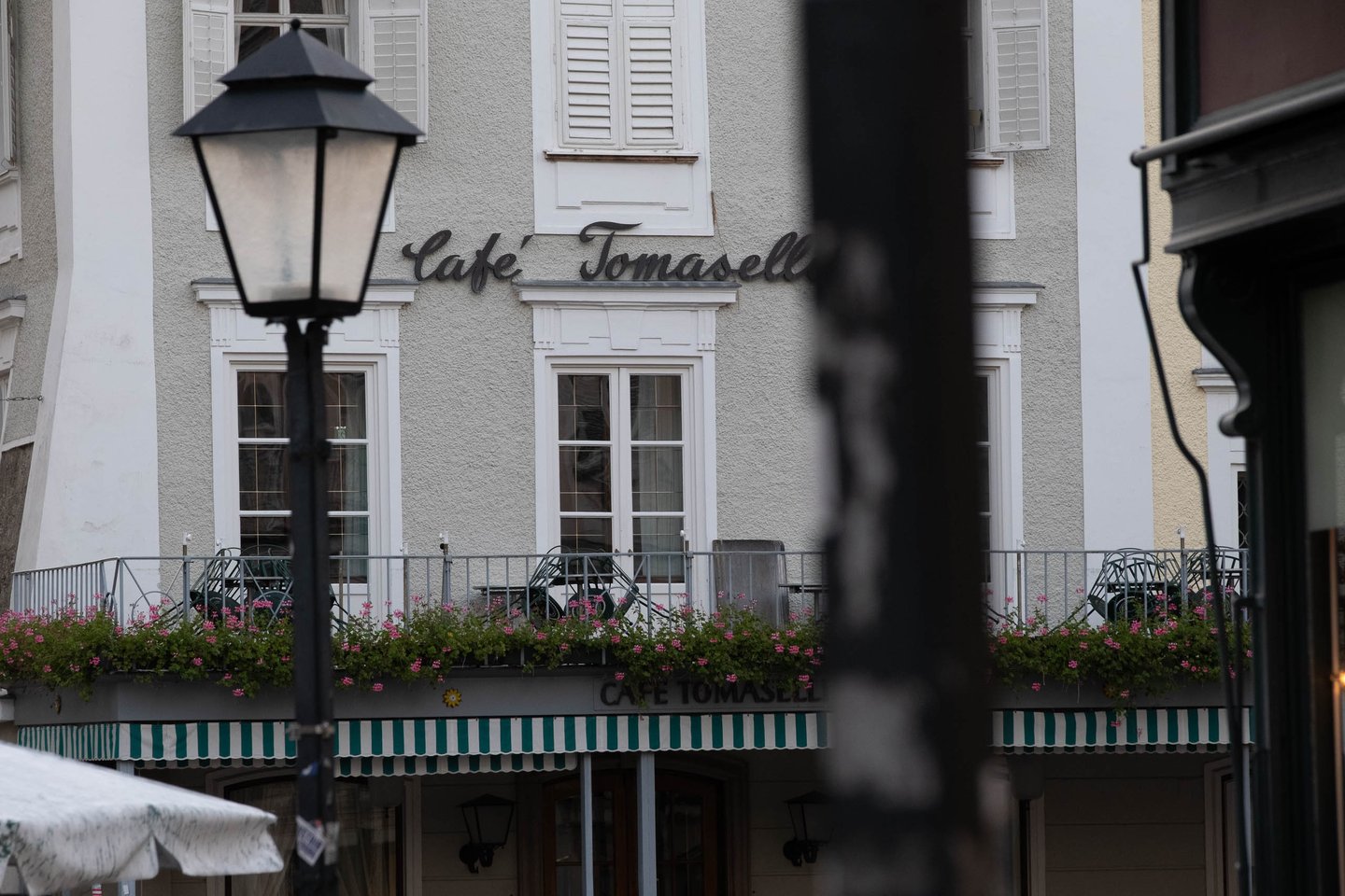 Cafe Tomaselli signage and flowerboxes on the historic Alter Markt facade in Salzburg.
