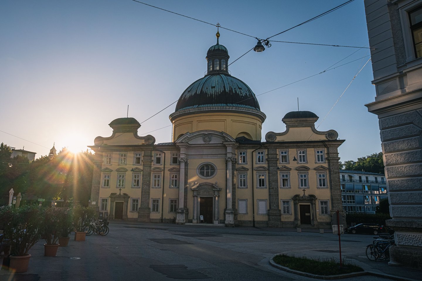 Cajetan Church domed facade on Kajetanerplatz at sunset in Salzburg.