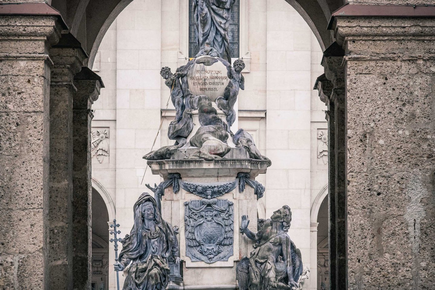 Marian Column framed through the baroque arches of Domplatz in Salzburg old town