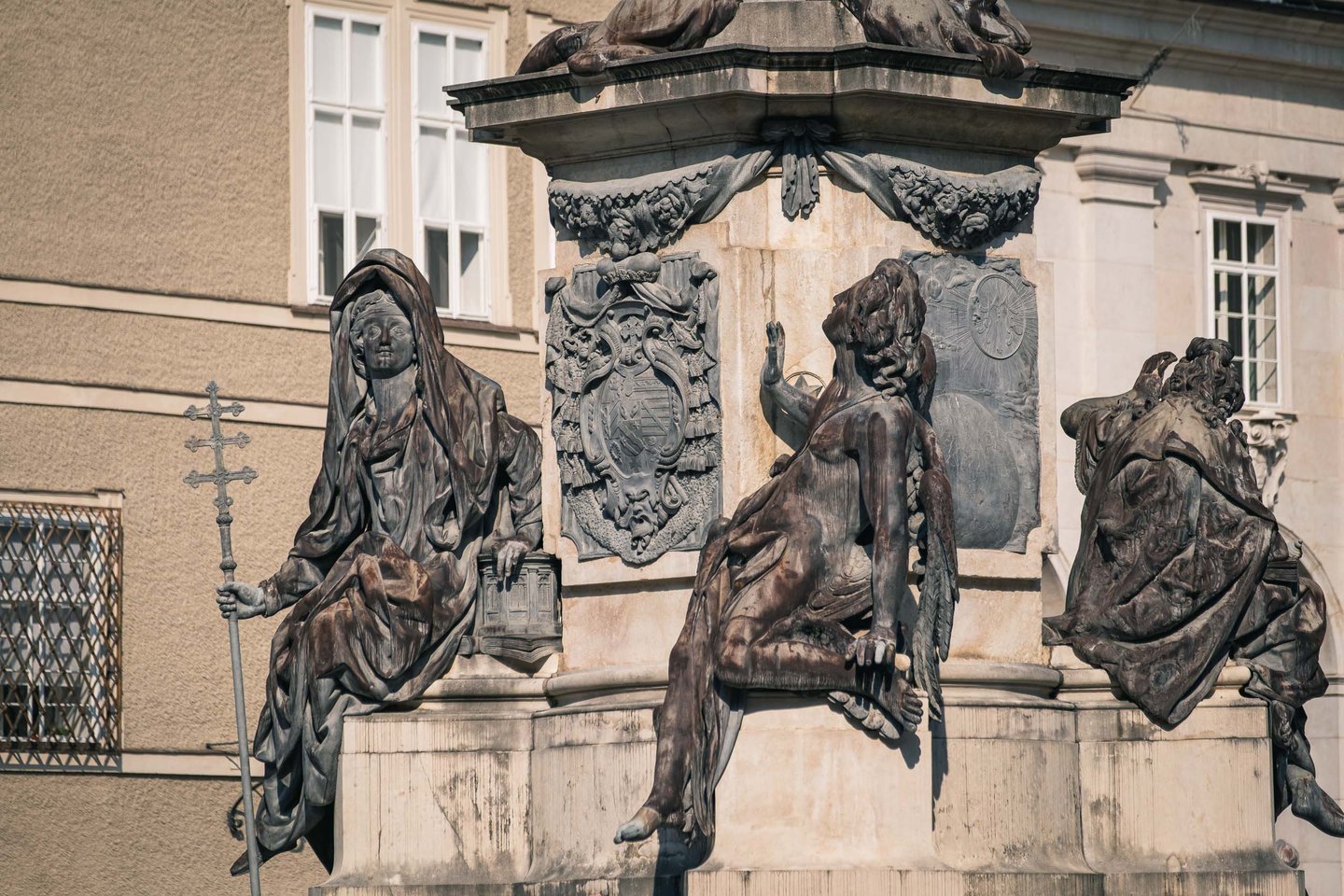 Bronze figures at the base of the Marian column on Domplatz in Salzburg old town
