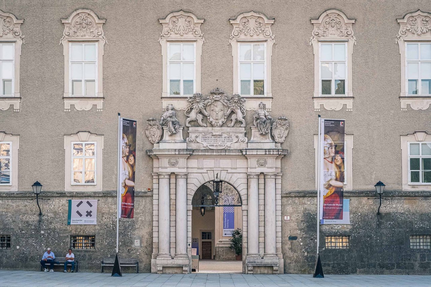 Baroque portal entrance of DomQuartier museum with heraldic coat of arms above the door in Salzburg