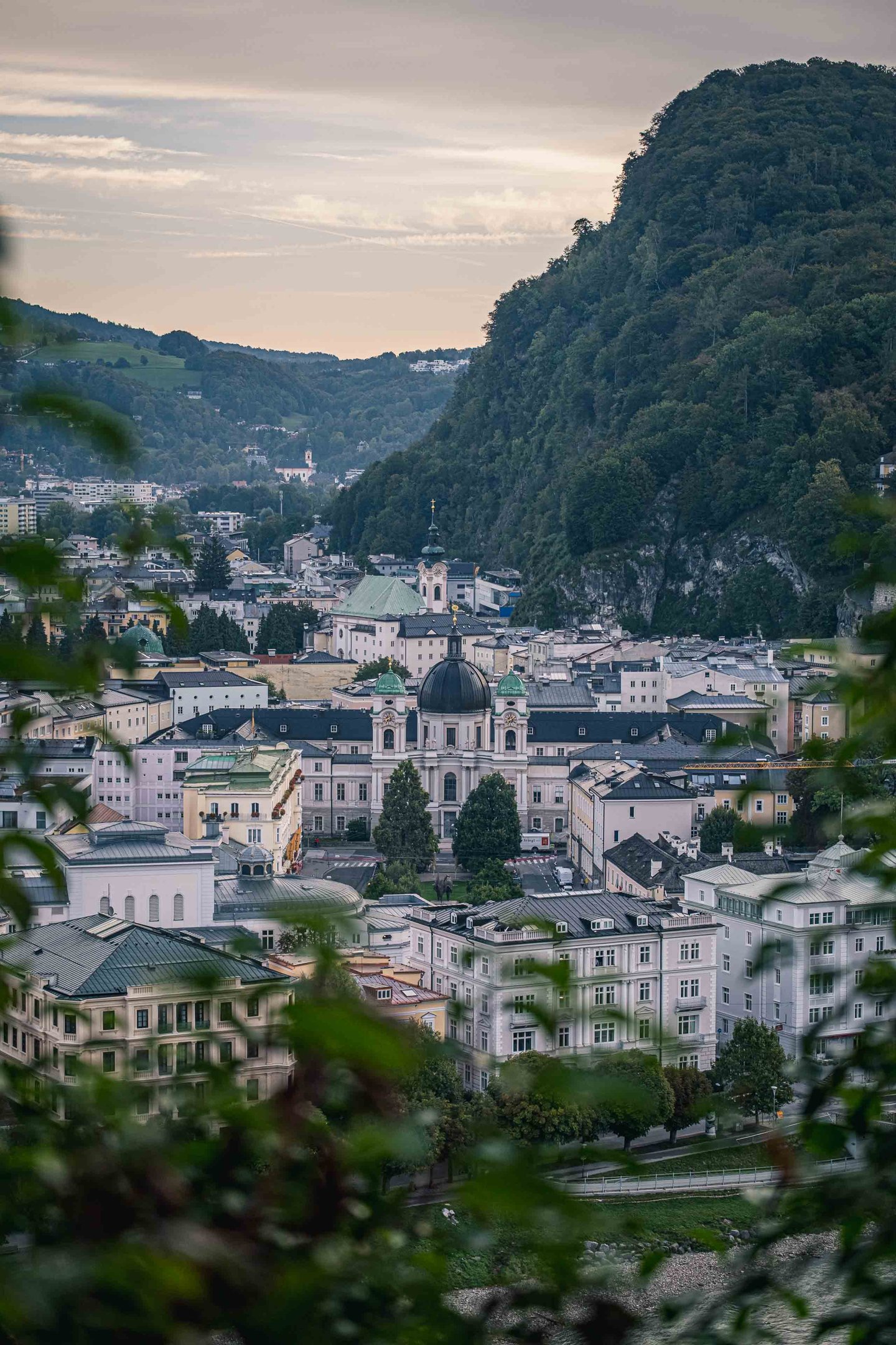 Dreifaltigkeitskirche dome framed by foliage seen from Kapuzinerberg in Salzburg.