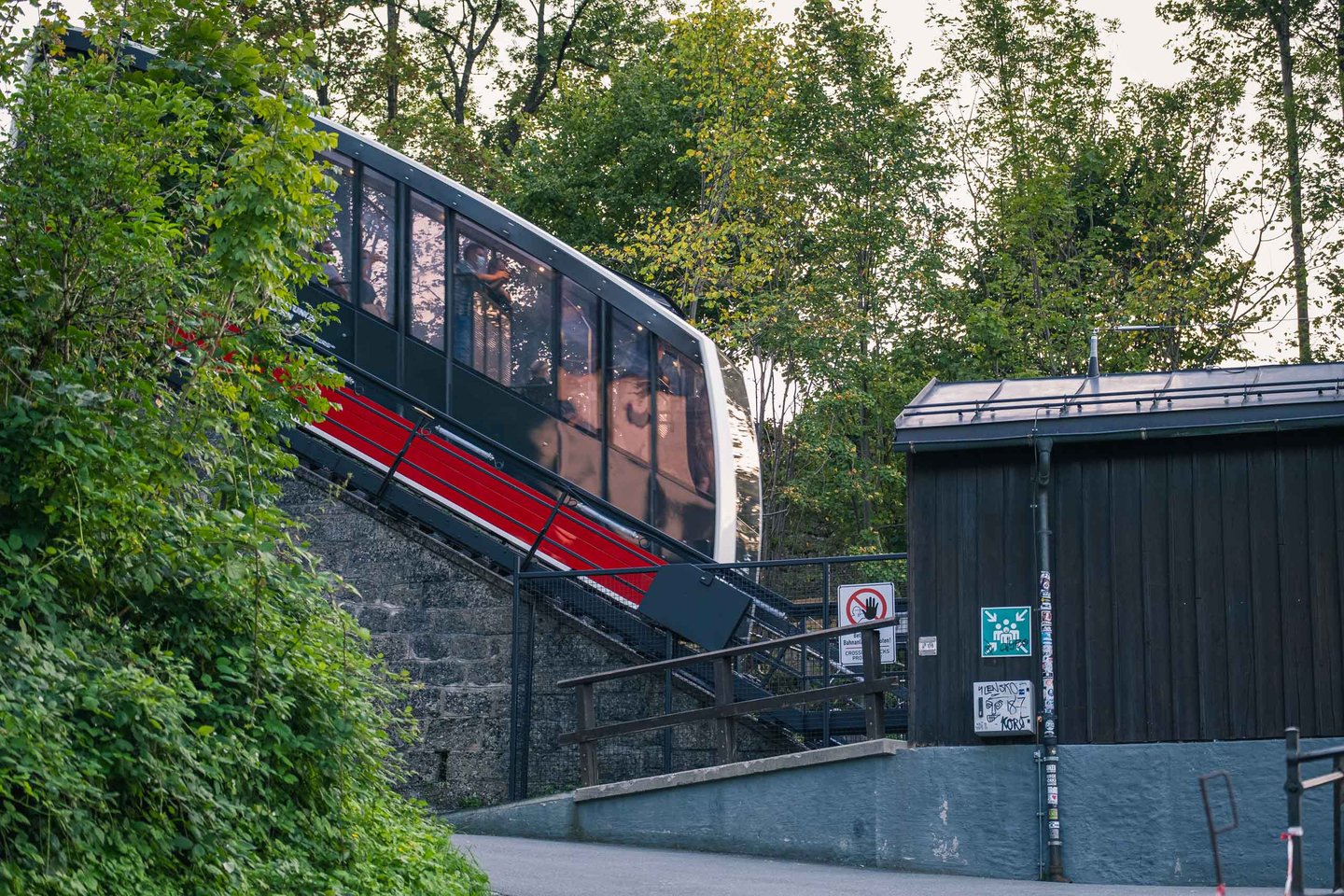 Red and black Festungsbahn funicular car climbing the track toward Hohensalzburg in Salzburg