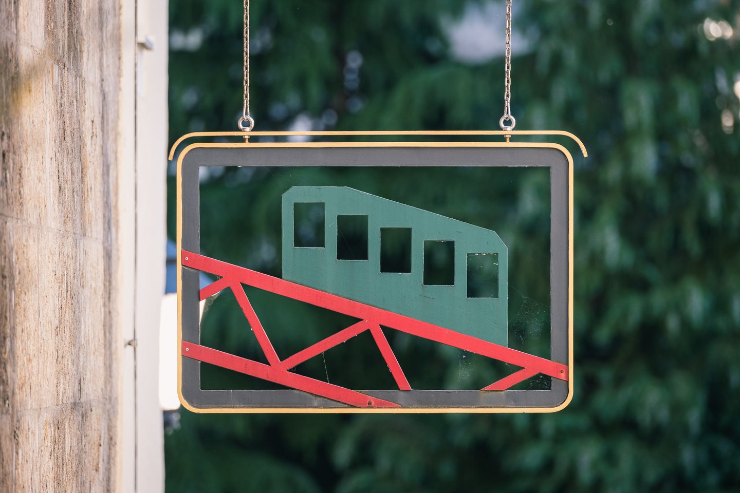 Festungsbahn funicular sign with green carriage and red rails in Salzburg old town.