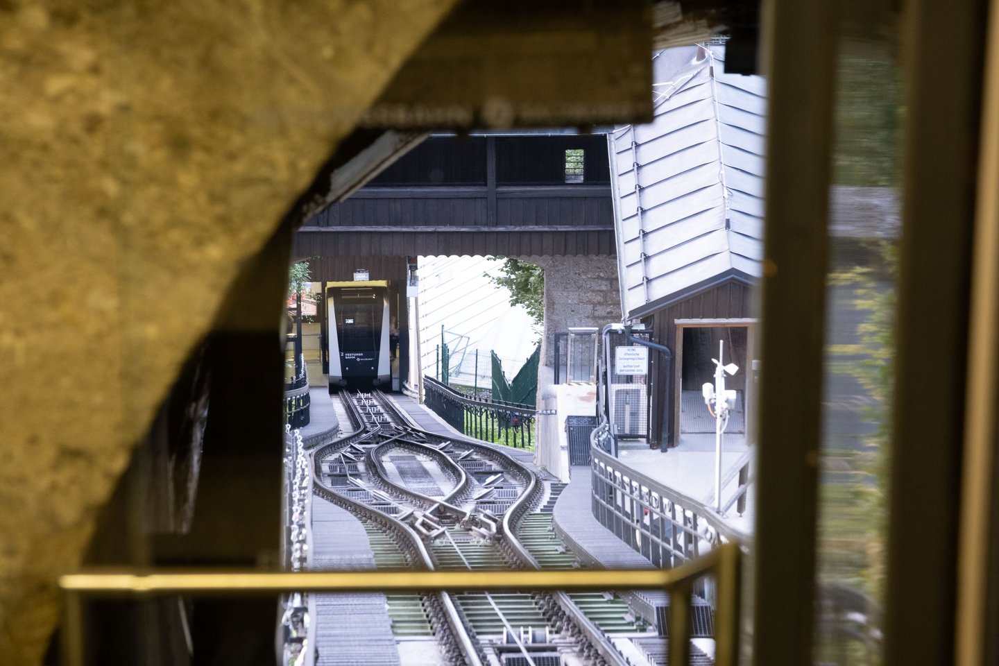Festungsbahn funicular car at the upper station tracks seen through fortress window in Salzburg