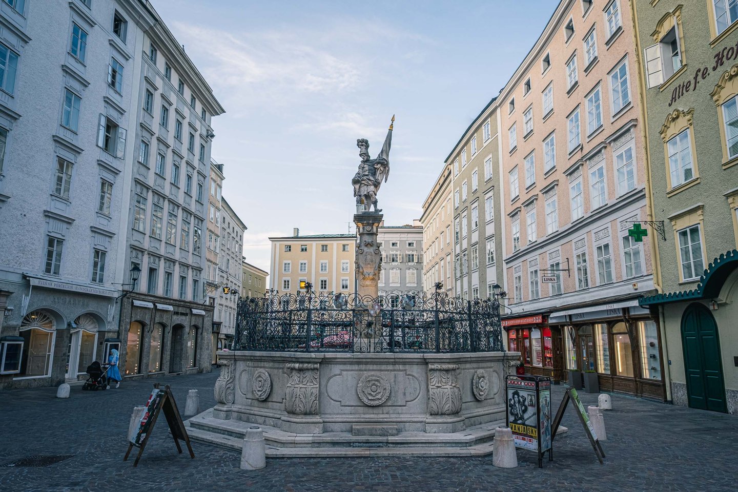 Baroque Florianibrunnen fountain with the Florian figure on Alter Markt square at dusk in Salzburg old town