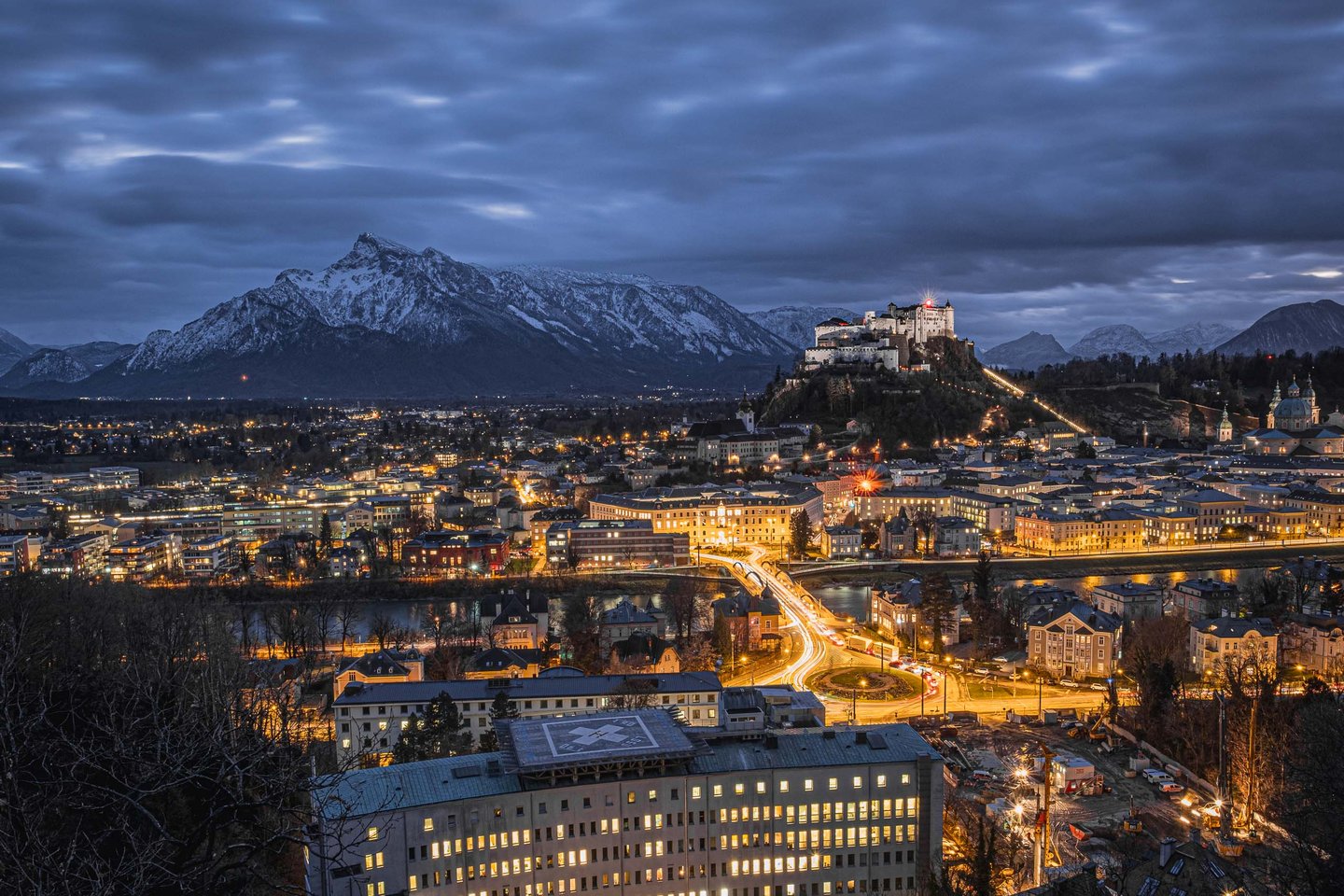 Hohensalzburg fortress above the old town at blue hour, seen from the Kapuzinerberg