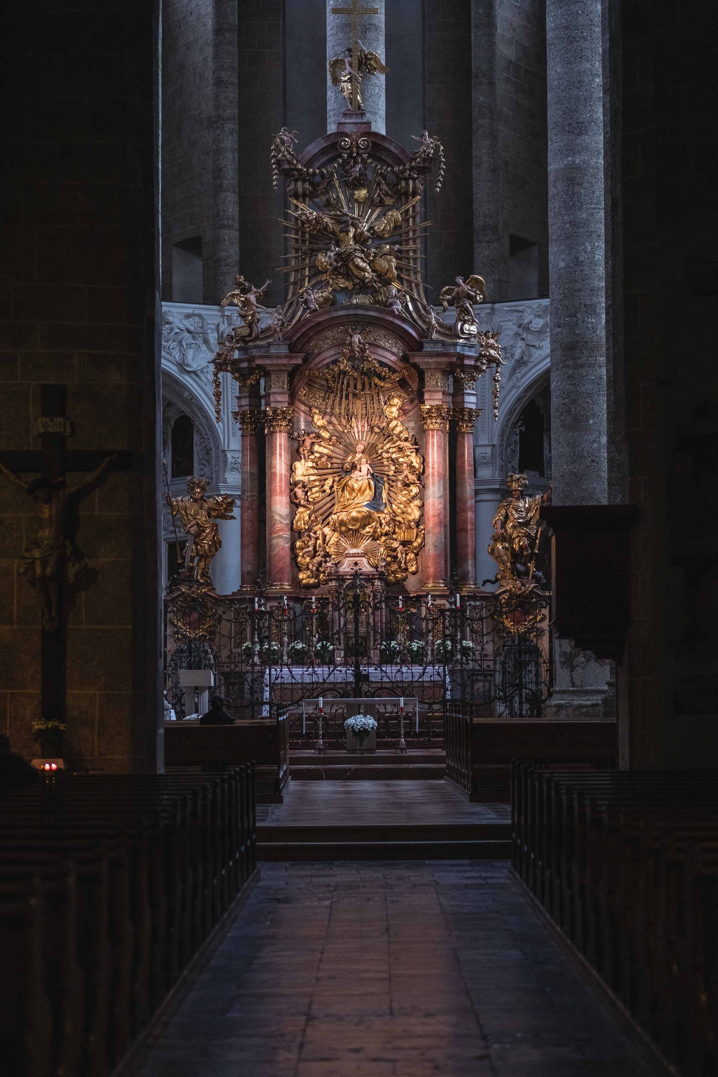 Baroque high altar with Madonna and golden rays inside Franziskanerkirche in Salzburg.