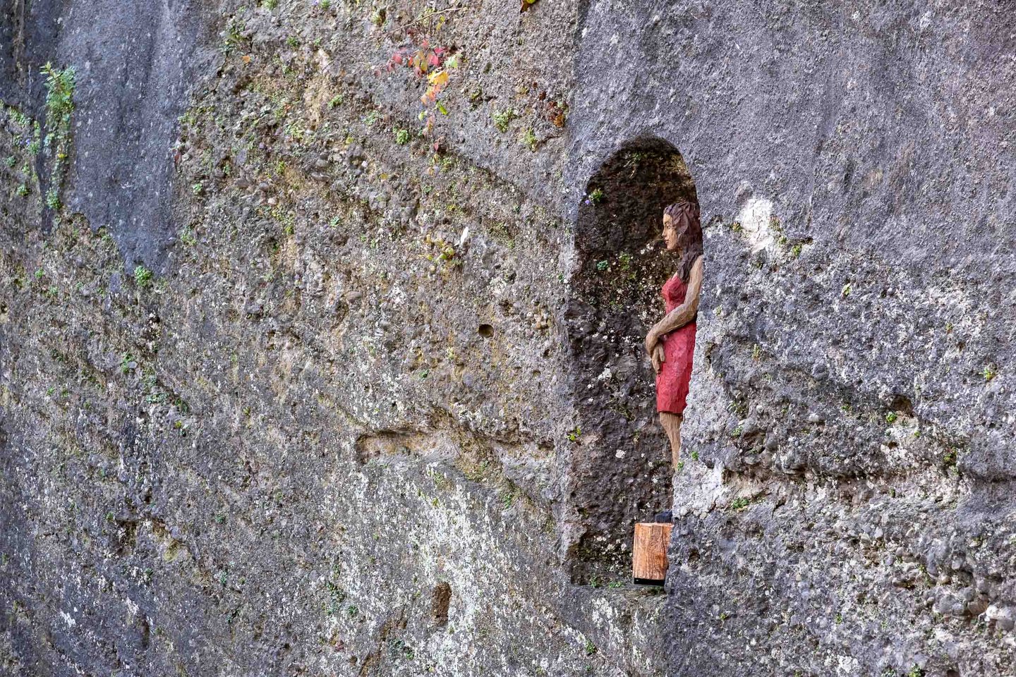 Frau im Fels sculpture by Stephan Balkenhol set into a rock niche on the Festungsberg in Salzburg, paired companion to the Sphaera on Kapitelplatz