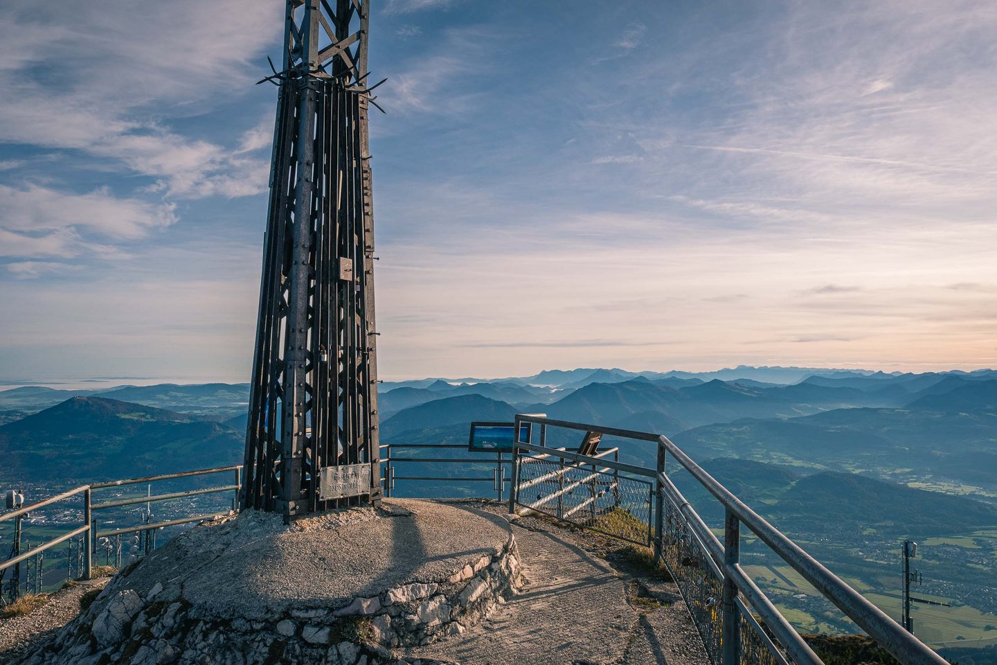 Iron summit cross at the Geiereck peak with panoramic Alpine foothills view near Salzburg