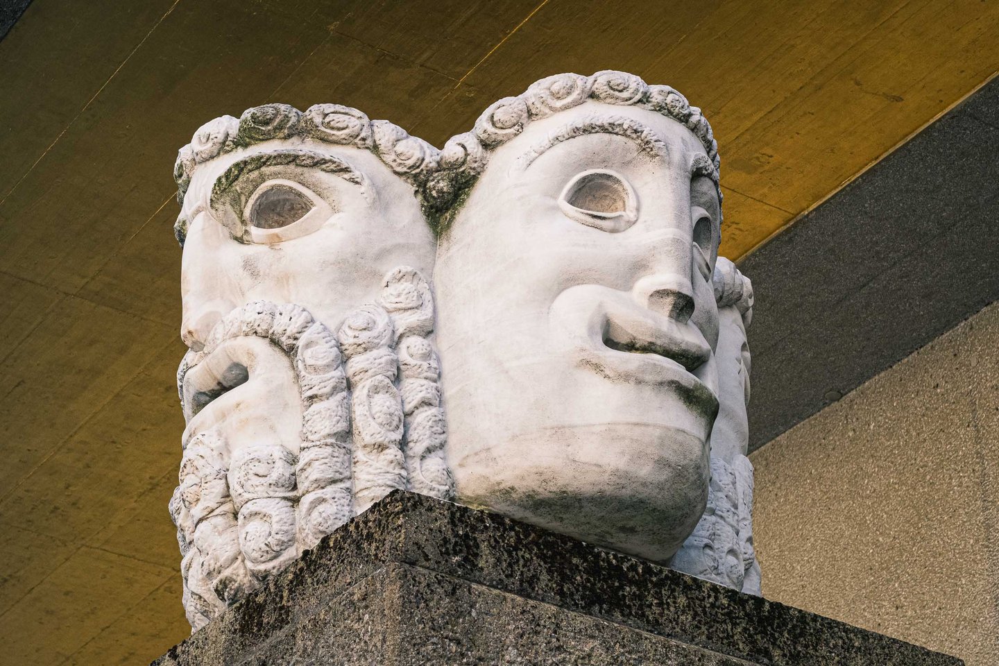 Carved stone double-head sculpture on a granite plinth in front of the Grosses Festspielhaus in Salzburg