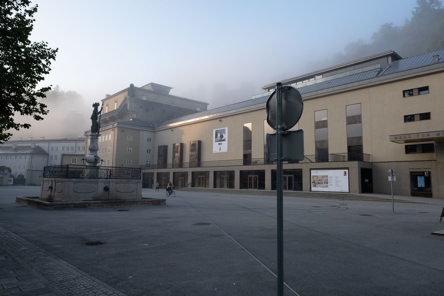 Haus für Mozart and Herbert von Karajan Platz fountain in morning fog in Salzburg