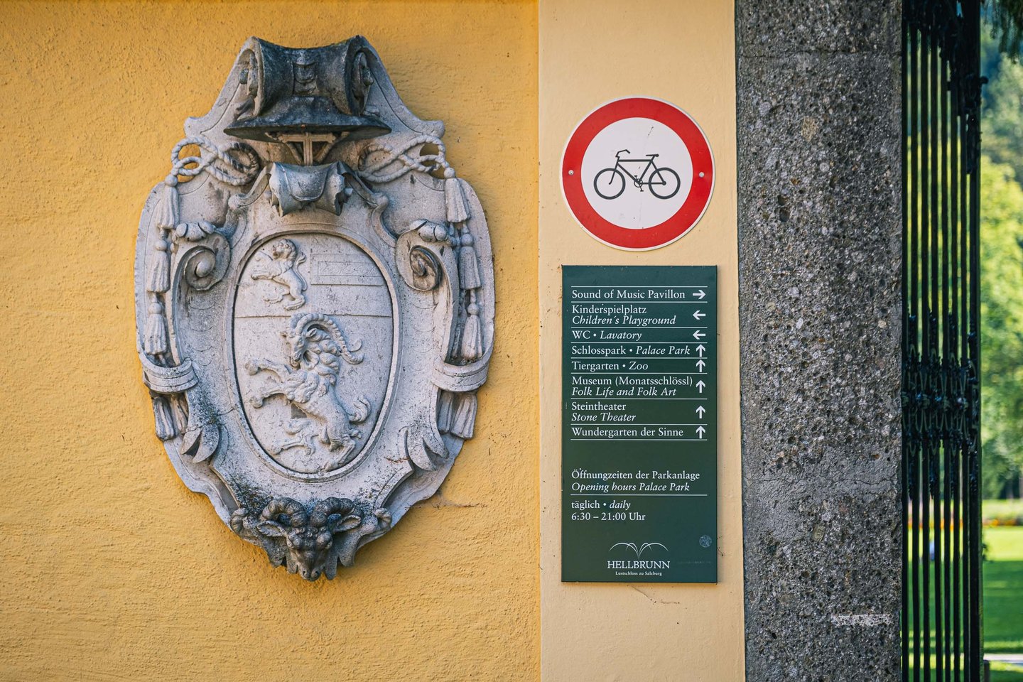 Hellbrunn coat of arms and park signage board at Schloss Hellbrunn gate near Salzburg.