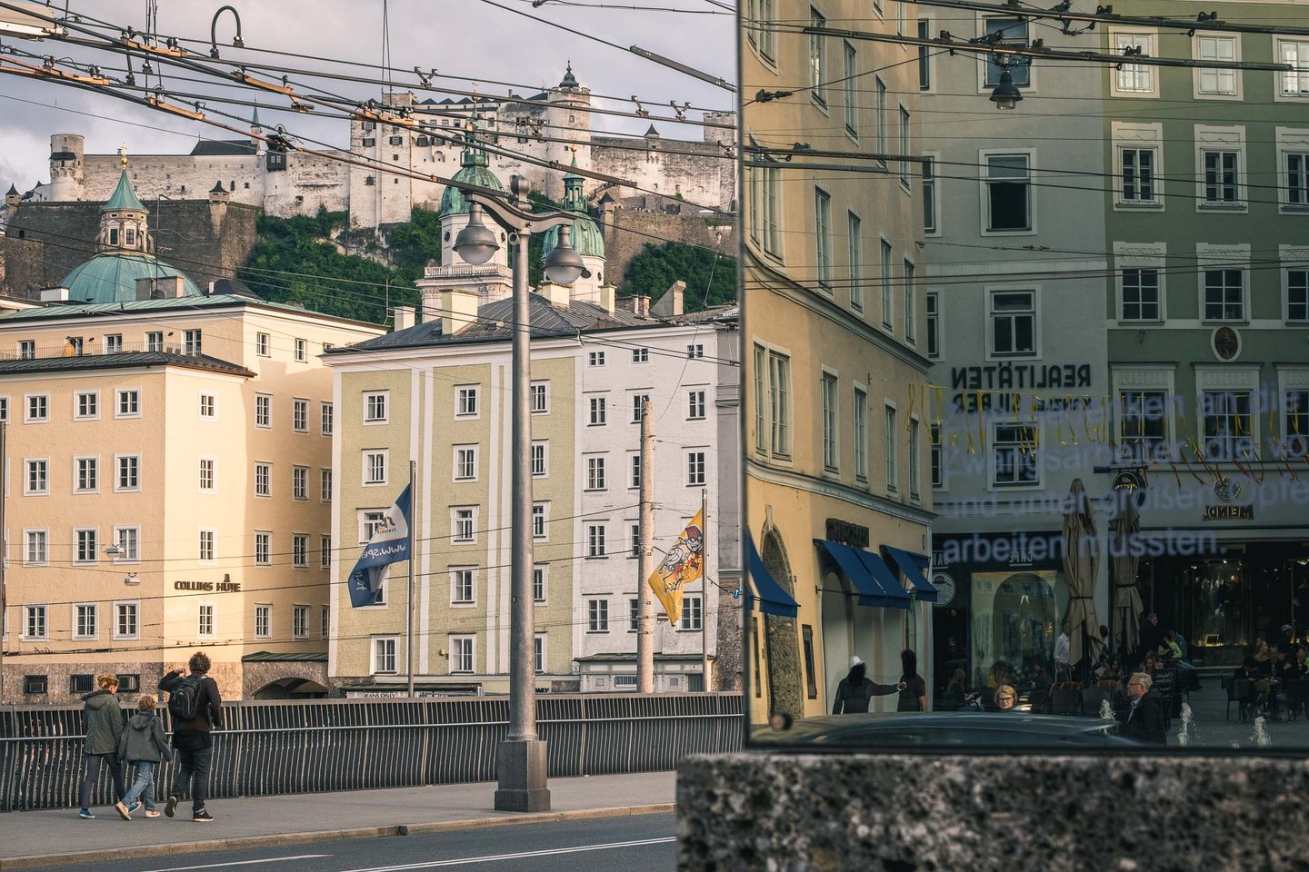 A trolleybus crosses the Staatsbrucke below Hohensalzburg fortress in Salzburg