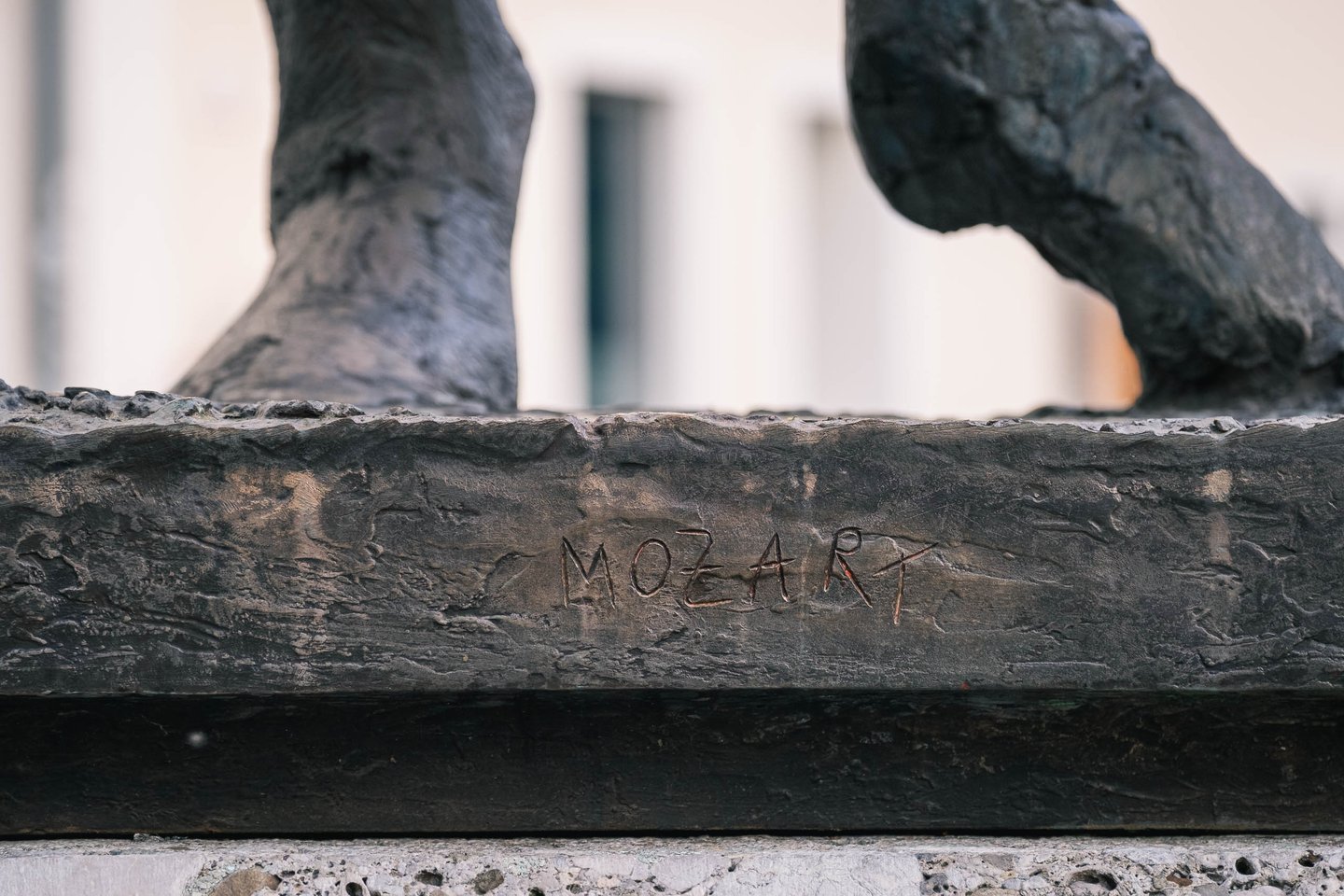 Close-up of the MOZART inscription carved into the base of the Homage to Mozart sculpture in Salzburg.