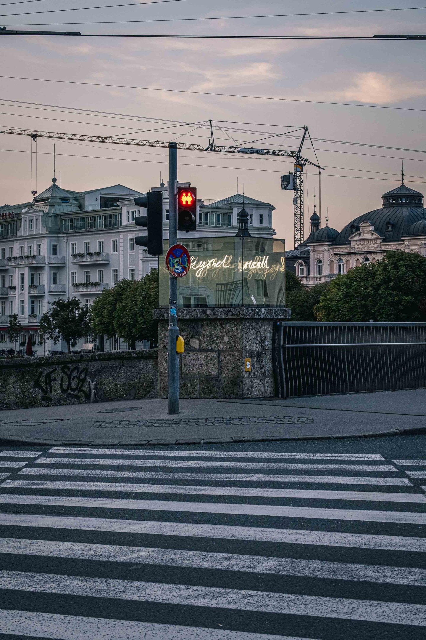 Hotel Sacher Salzburg at dusk with crane and pedestrian traffic light on the Staatsbrucke in Salzburg