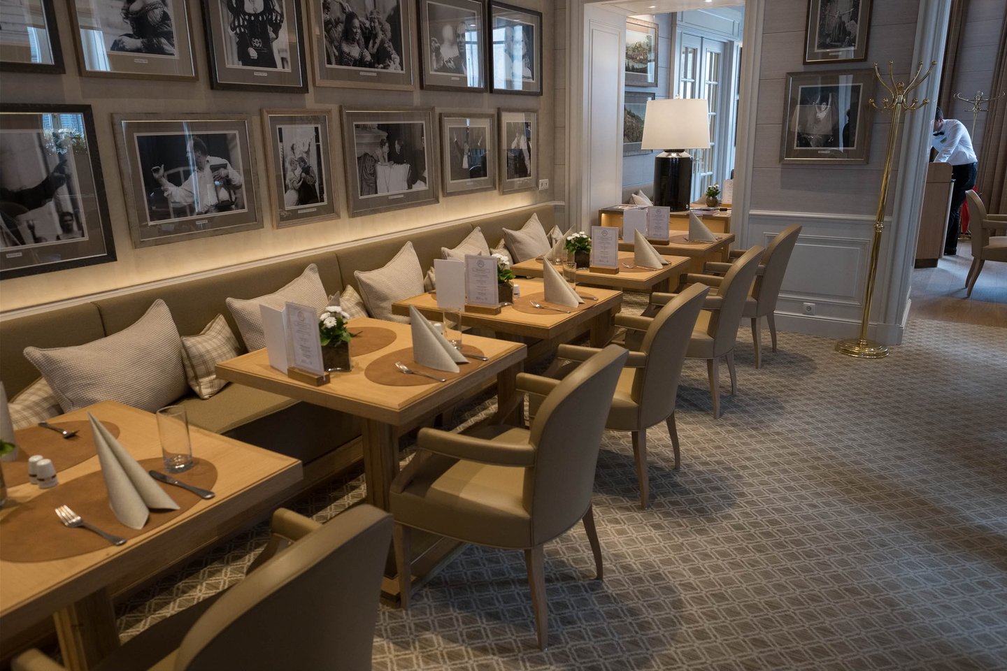 Empty beige dining room with framed festival photographs inside Hotel Sacher Salzburg