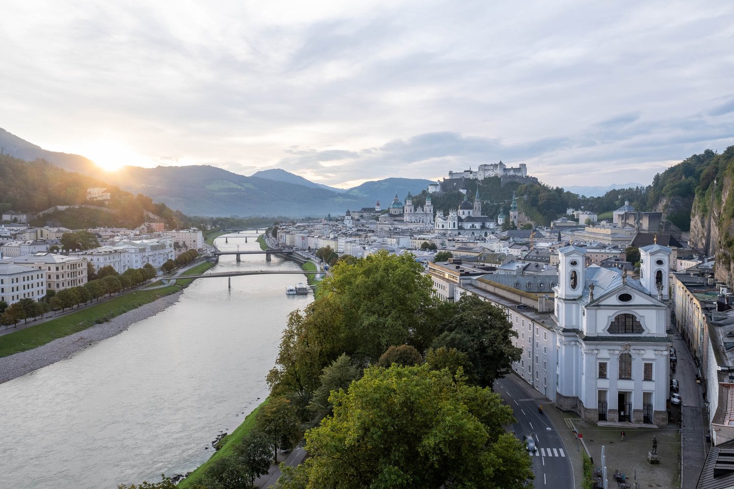 Humboldtterrasse panorama of Salzach River and Altstadt with fortress and Dreifaltigkeitskirche in Salzburg.