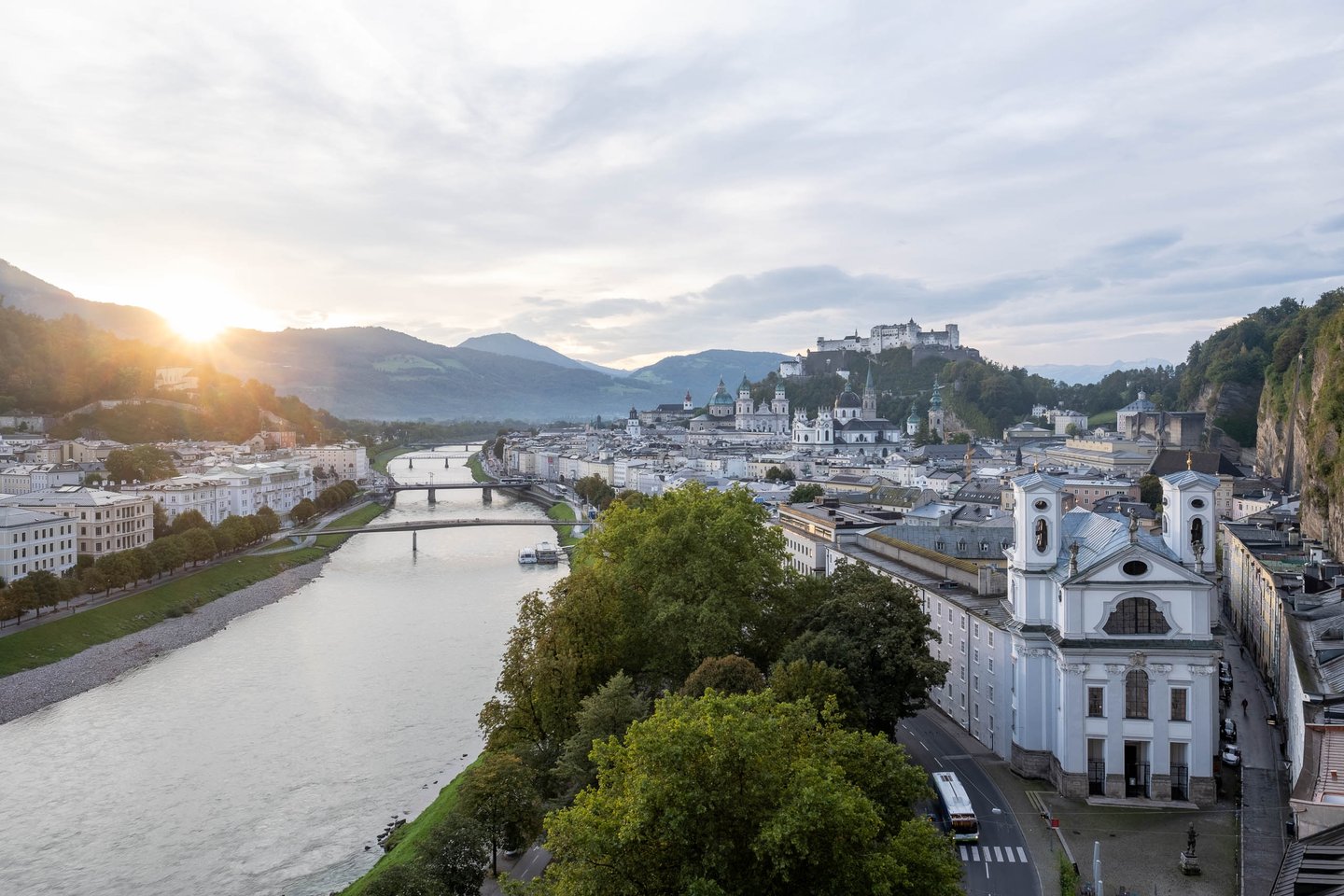 View from Humboldtterrasse at dawn with Salzach River old town fortress and Dreifaltigkeitskirche in Salzburg.