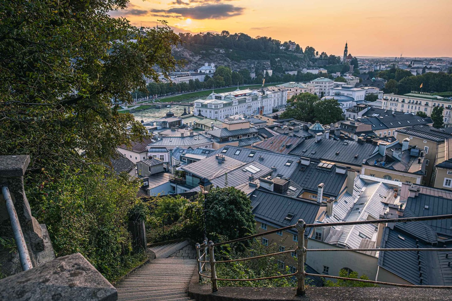 View from the Imbergstiege over Altstadt rooftops and the Salzach at golden hour in Salzburg