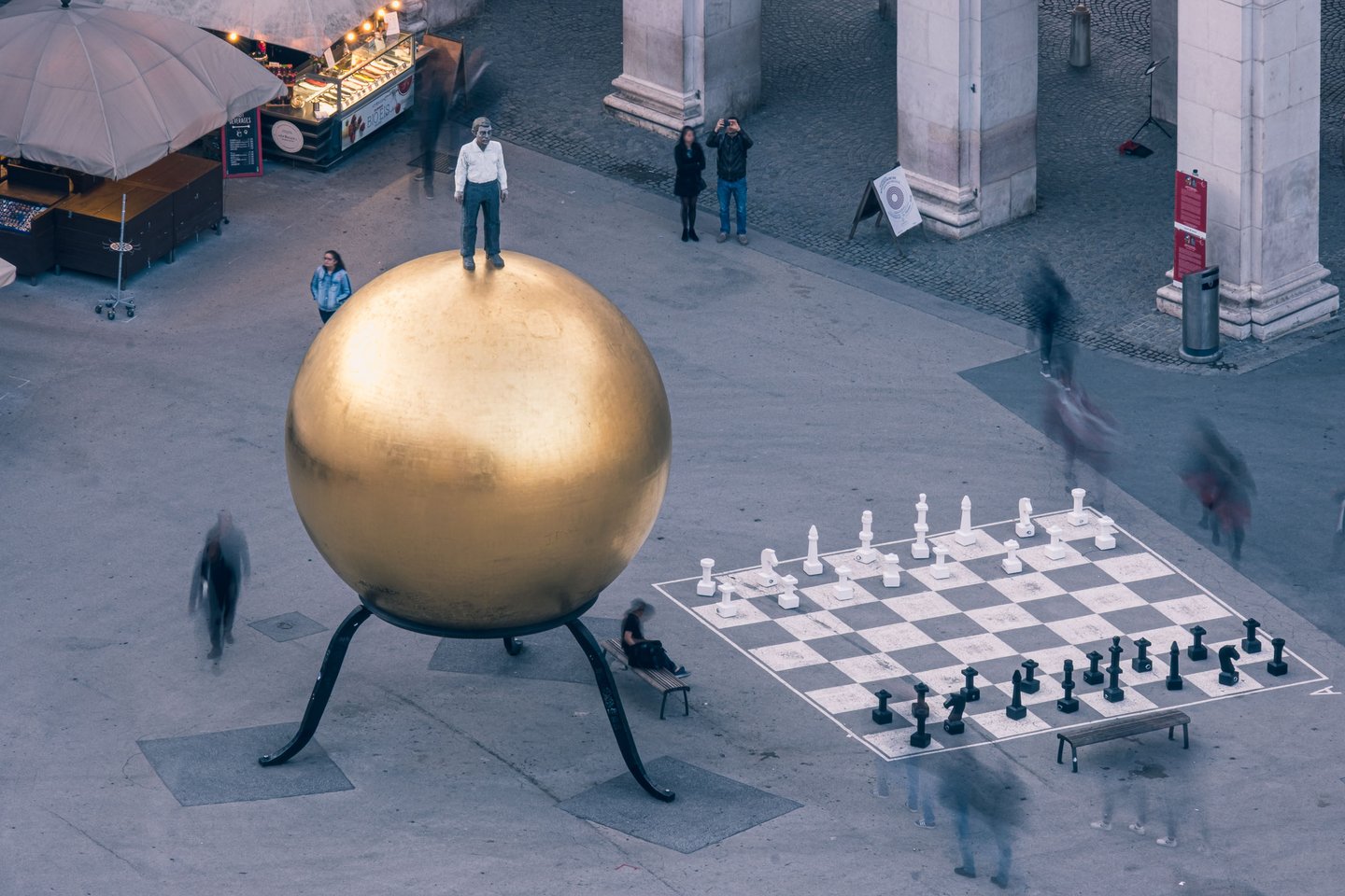 Sphaera golden ball and giant outdoor chess board with people on Kapitelplatz in Salzburg